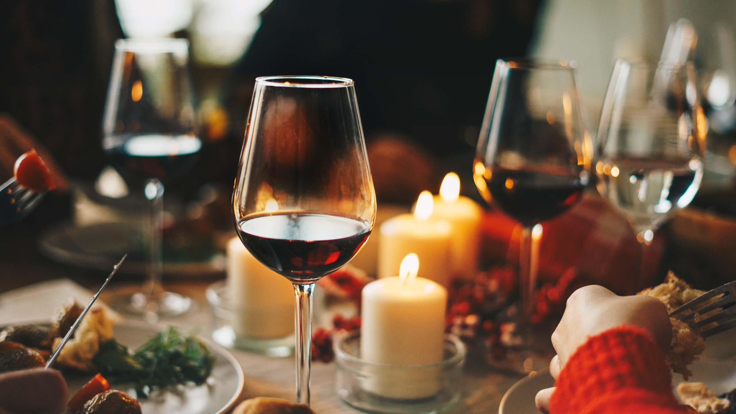 Red wine glasses at the decorated dinner table