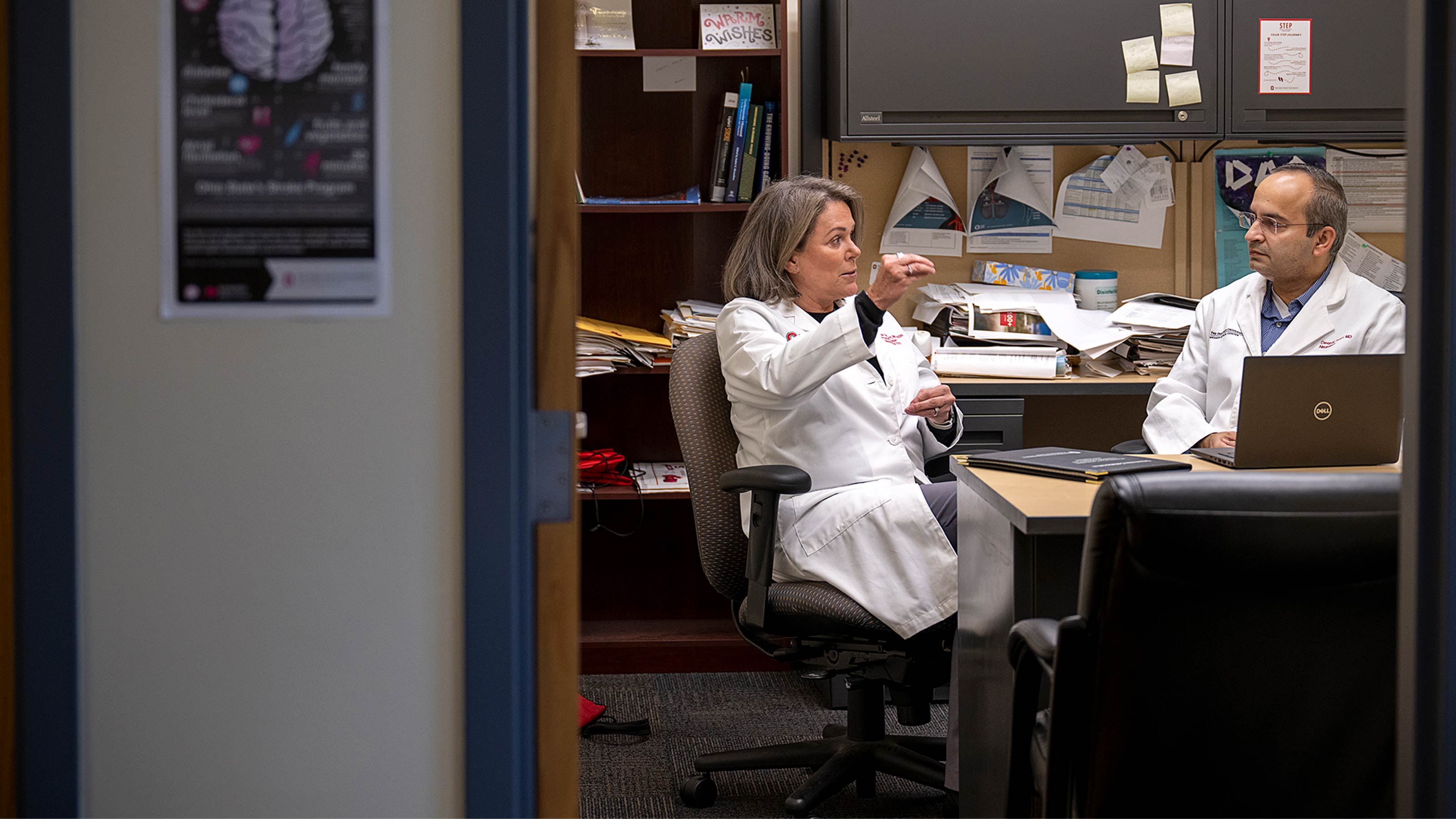 Ohio State neurologist, Deepak Gulati, MD, talking with another doctor in his office