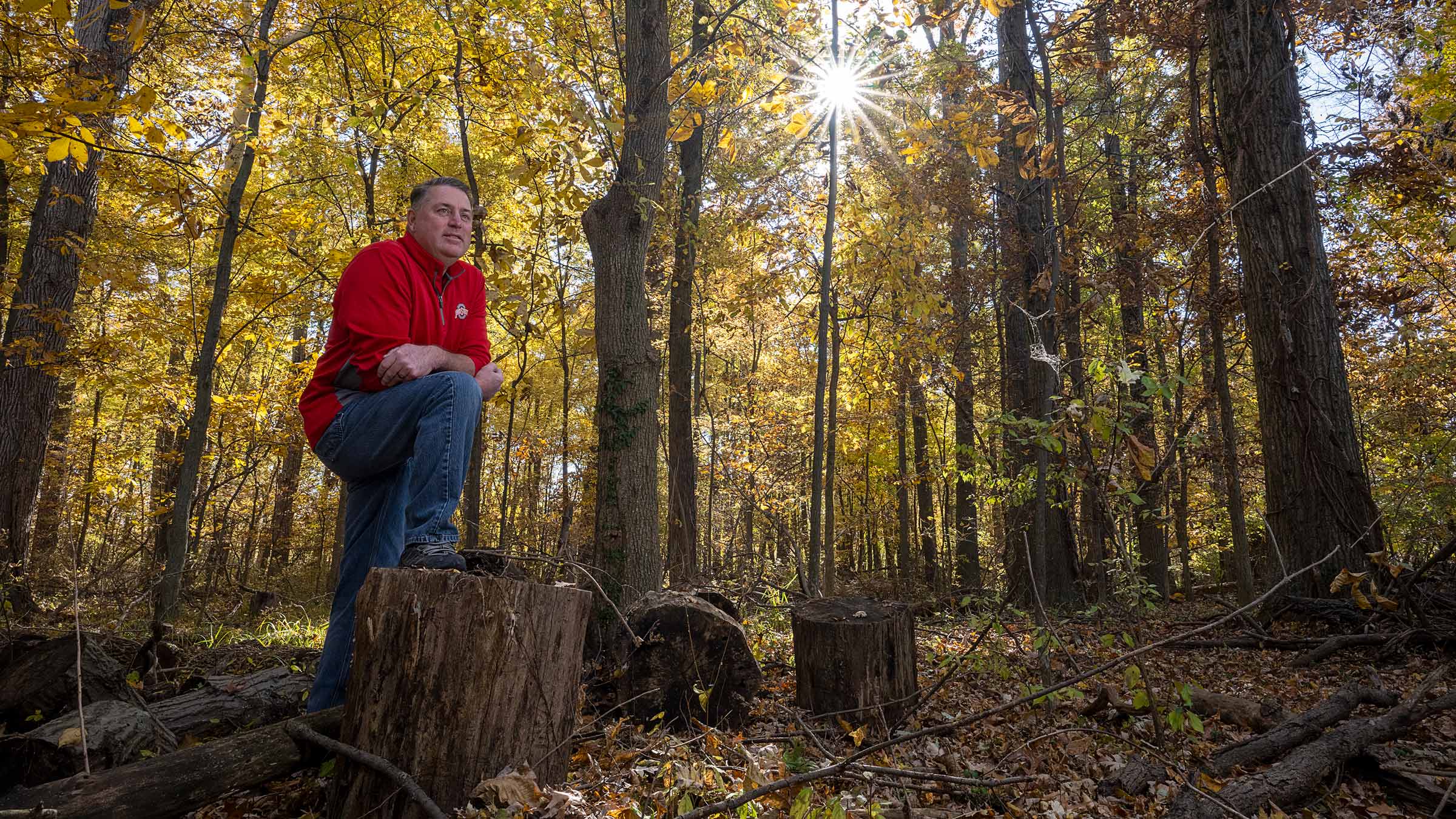 Duane Gross smiling in the woods near his home