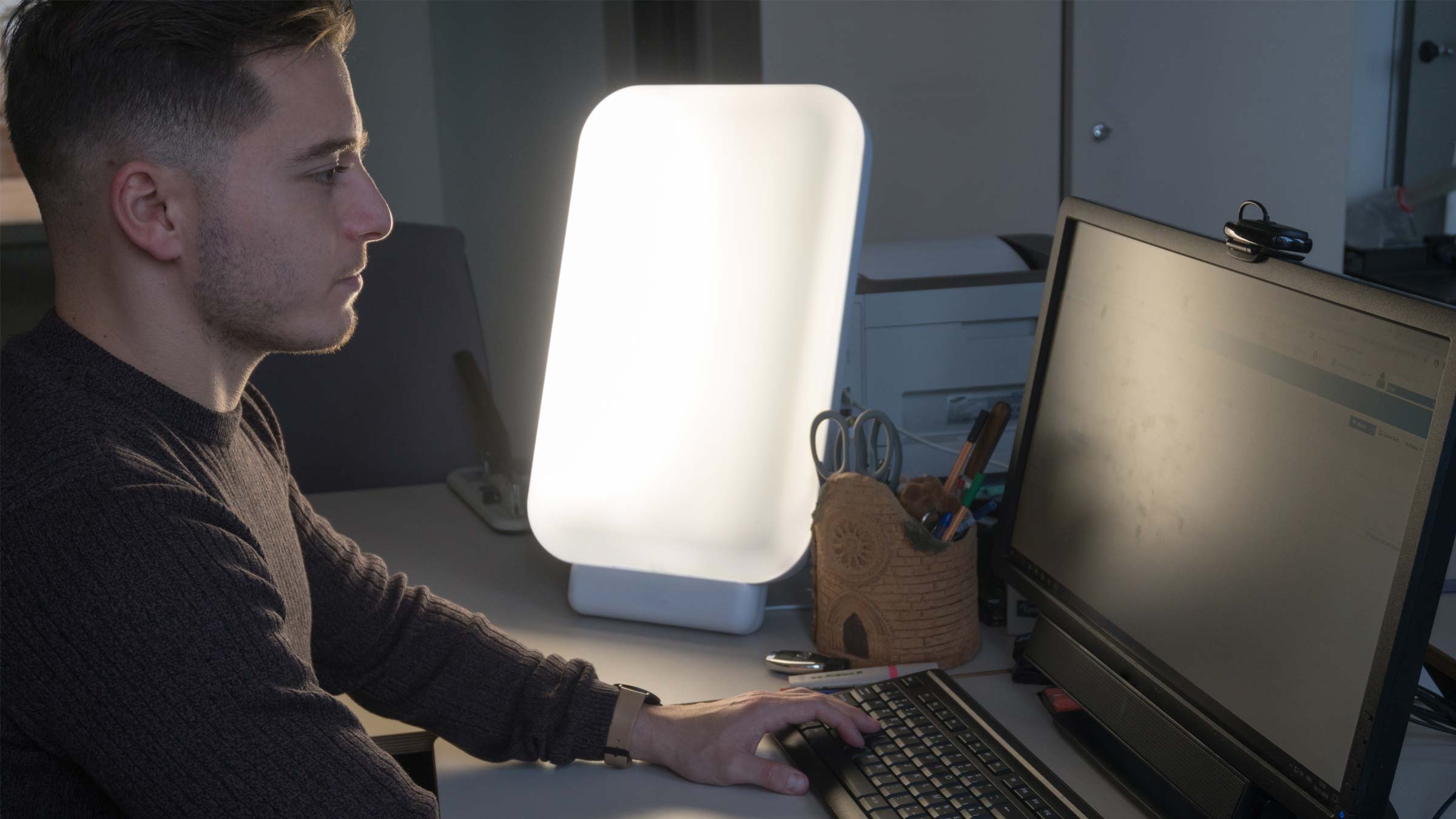 A person using a light therapy lamp for their seasonal affective disorder.