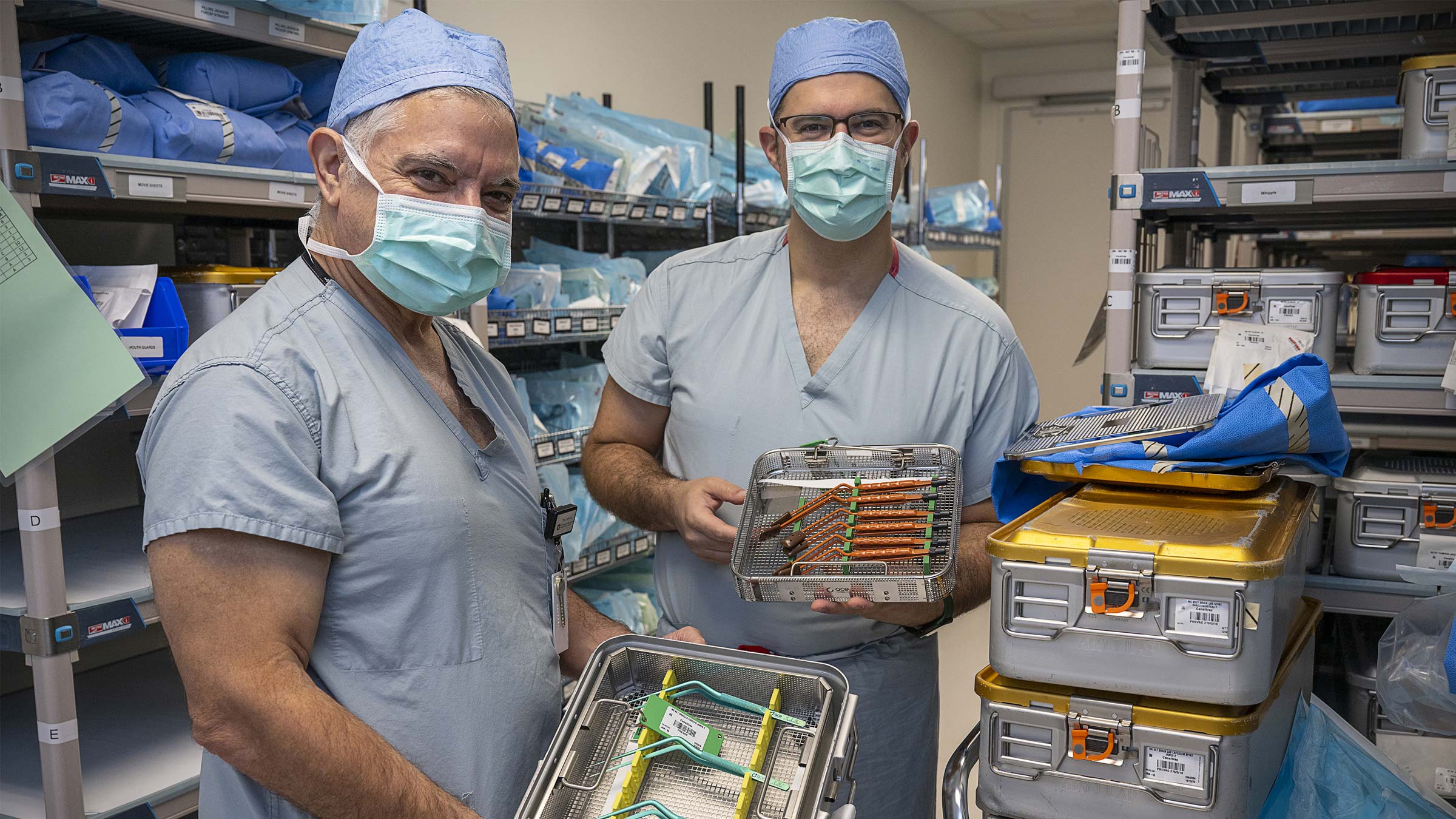 Dr. Carrau and Dr. Prevedello, in scrubs, holding instruments they designed for skull base surgery