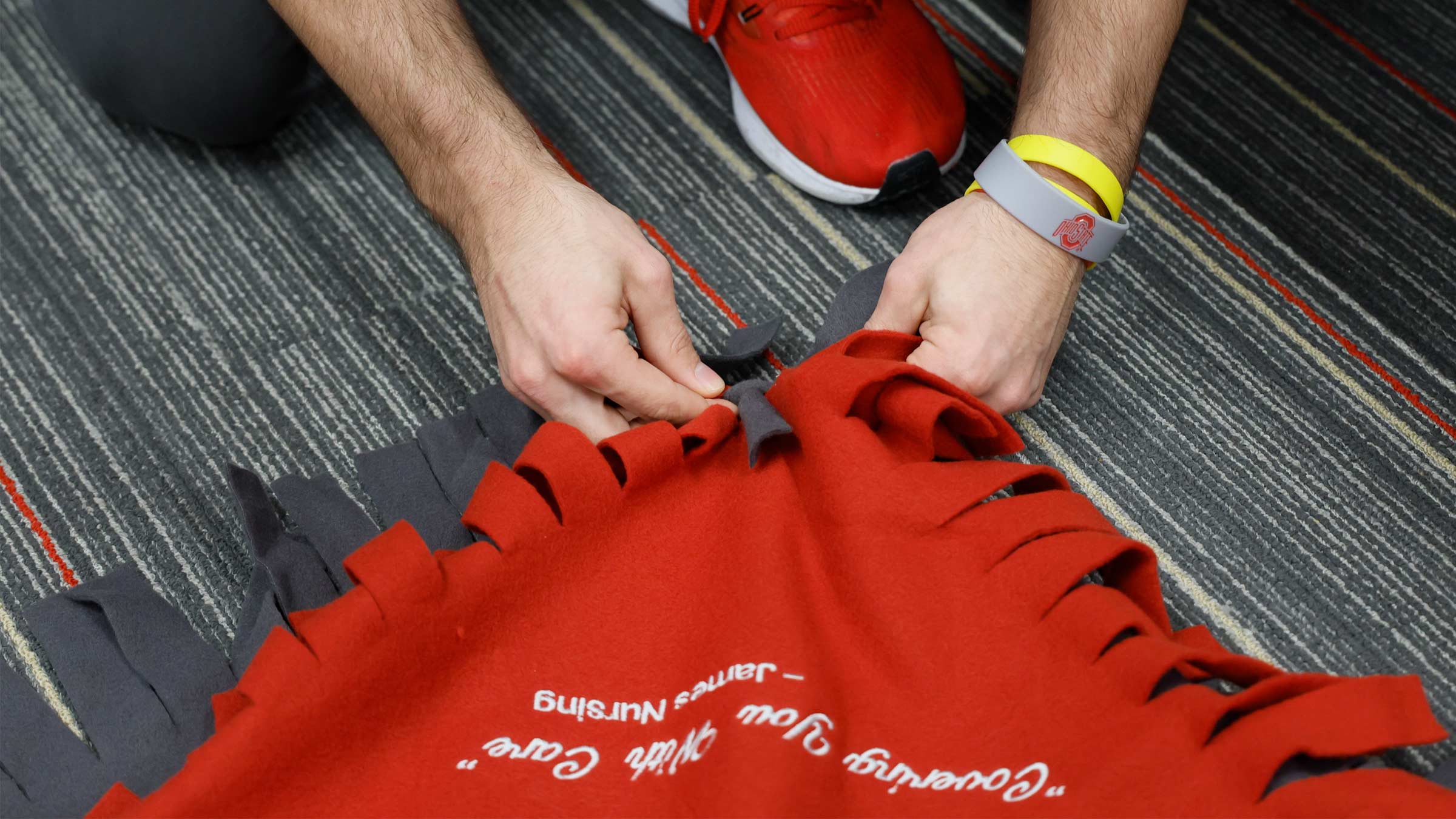 Member of the Ohio State wrestling team making a blanket