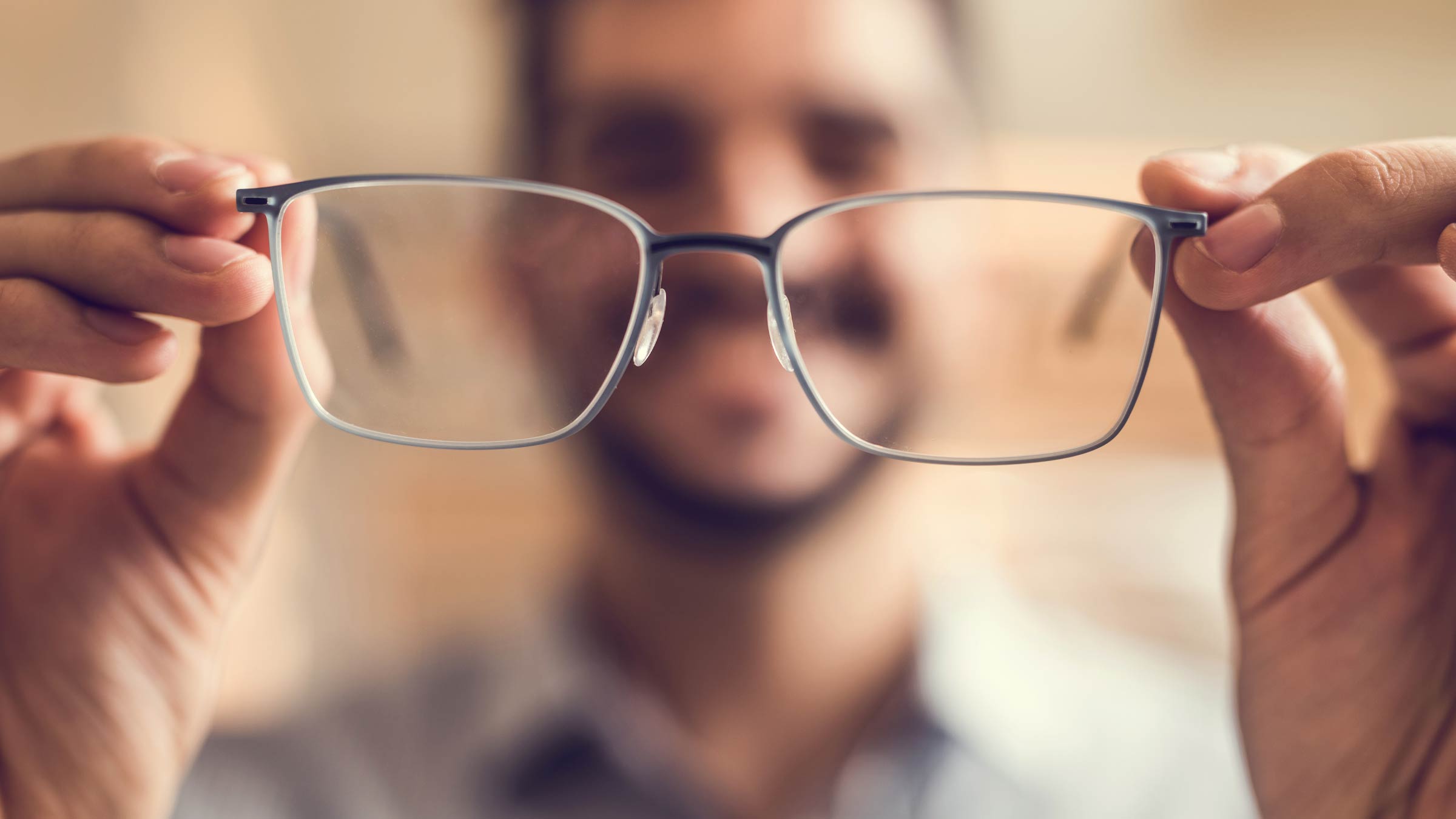 Close up of a man getting ready to try on glasses