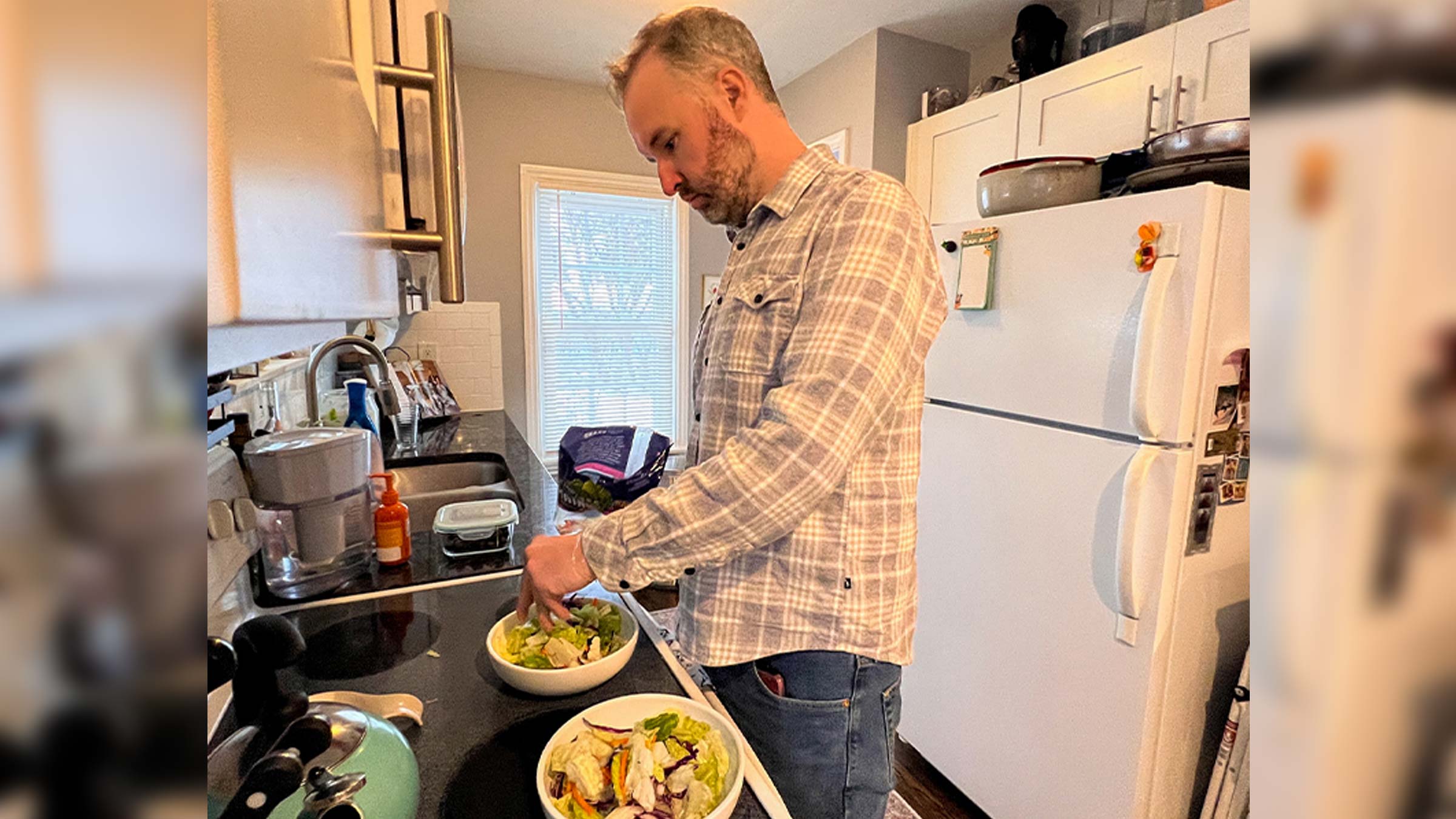 Patient Dave Conway makes a salad in his kitchen