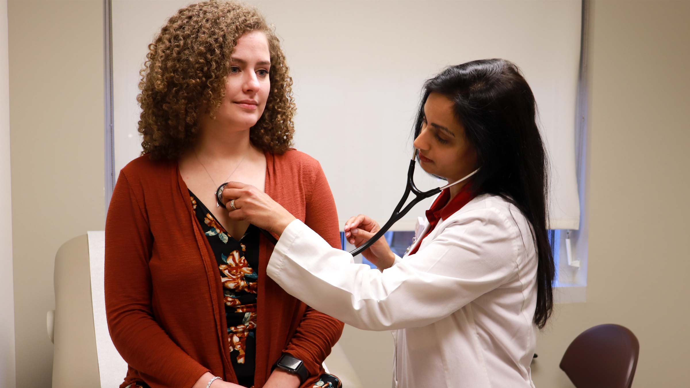 Dr. Laxmi Mehta, an Ohio State cardiologist, listens to a female patient’s heartbeat