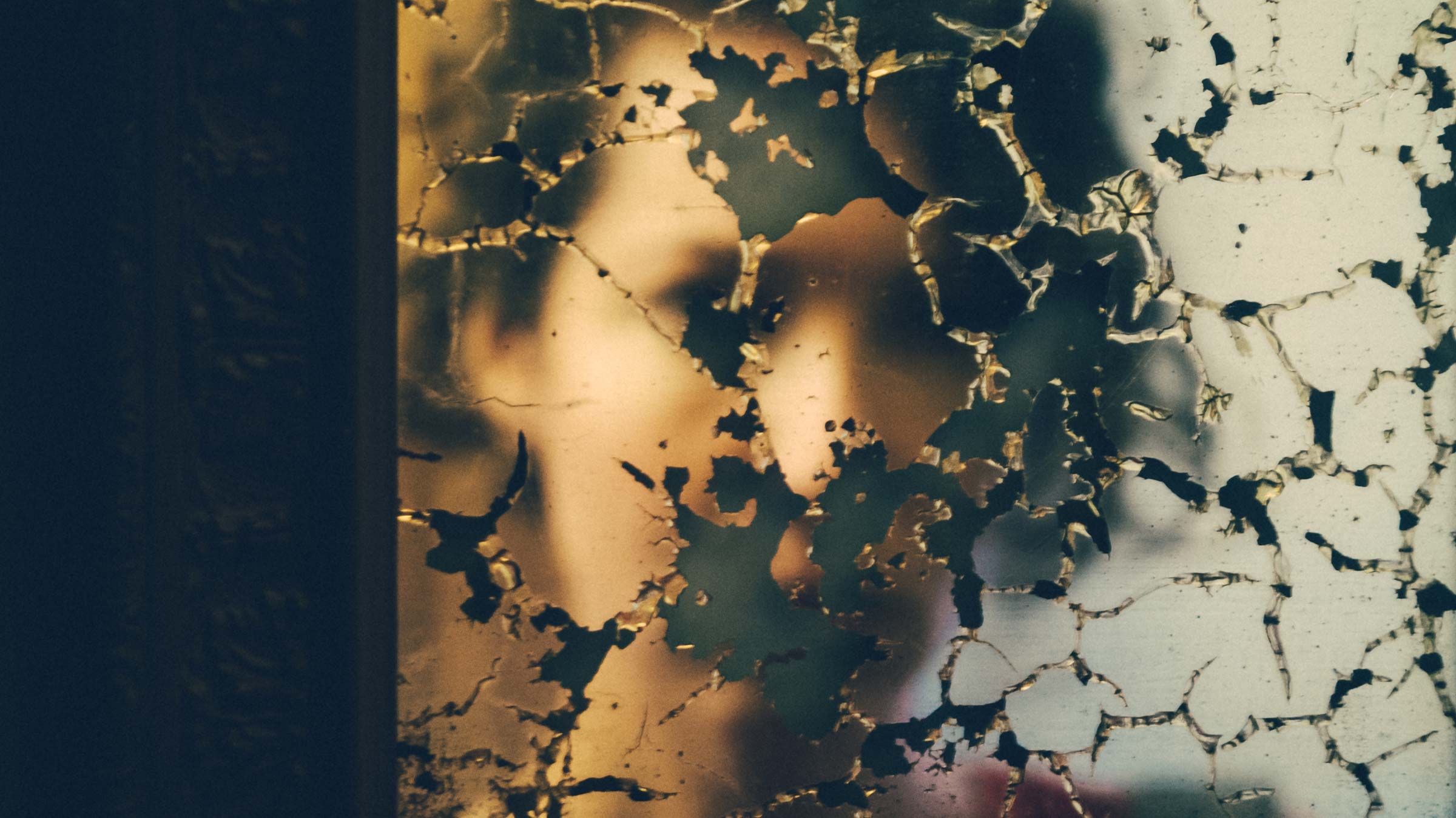 A young woman's reflect in a damaged mirror