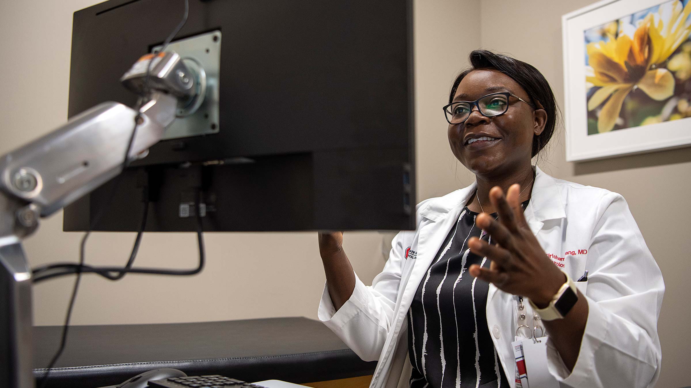 Tirisham Gyang, MD, a clinical assistant professor of neurology at Ohio State working on a computer