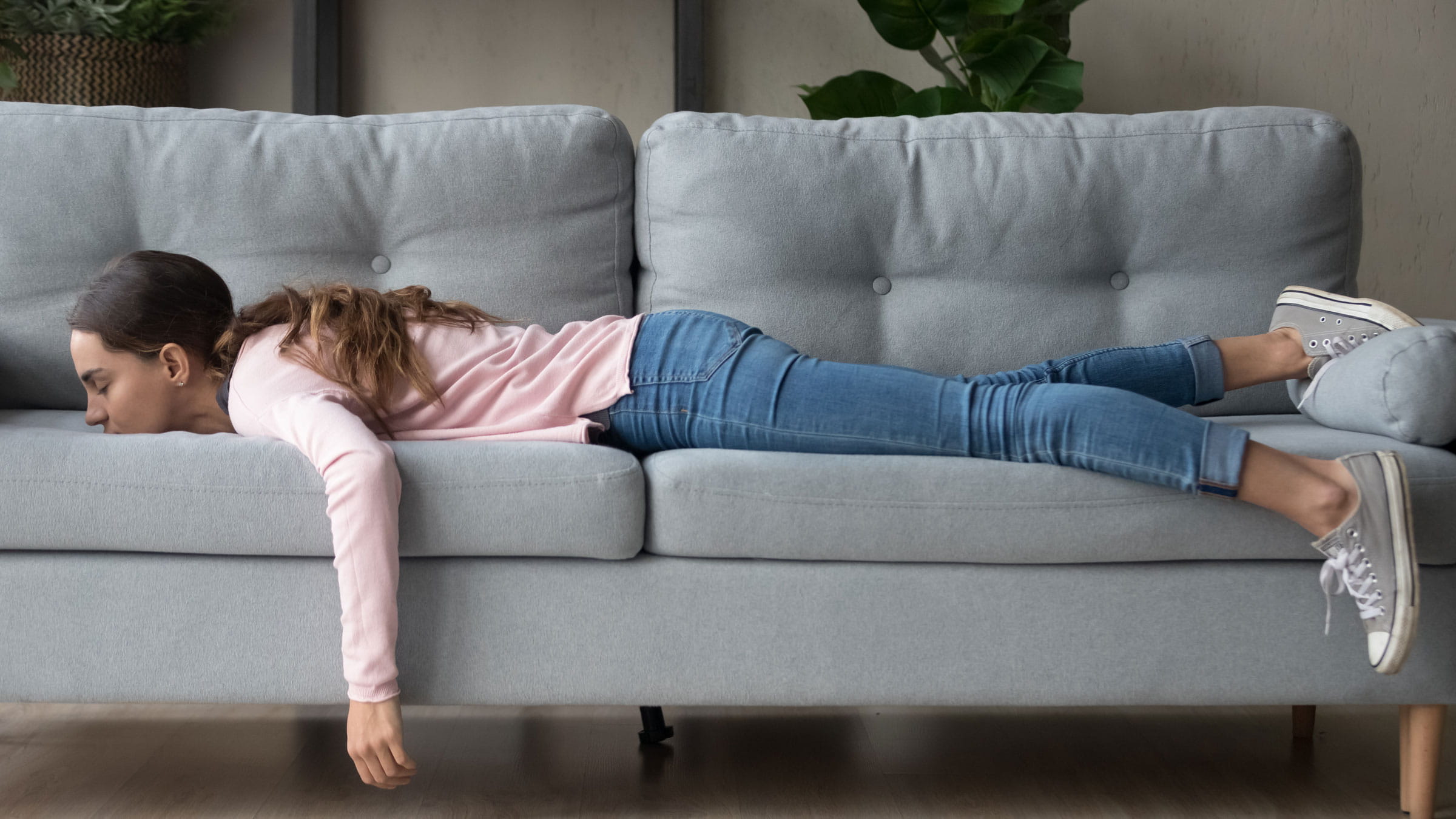 Tired woman lying face-down on a couch