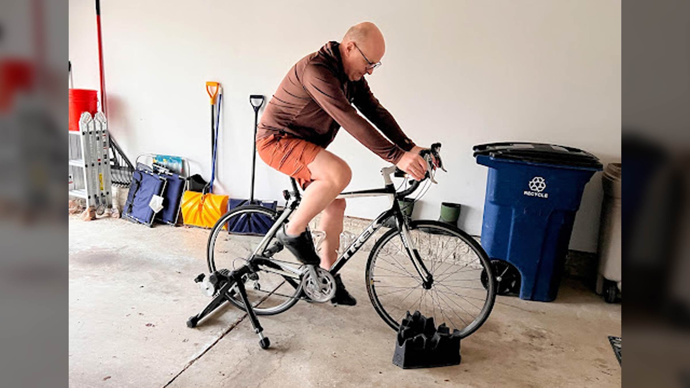 Angel Kowalski, a cancer survivor, works out on a bike in his garage