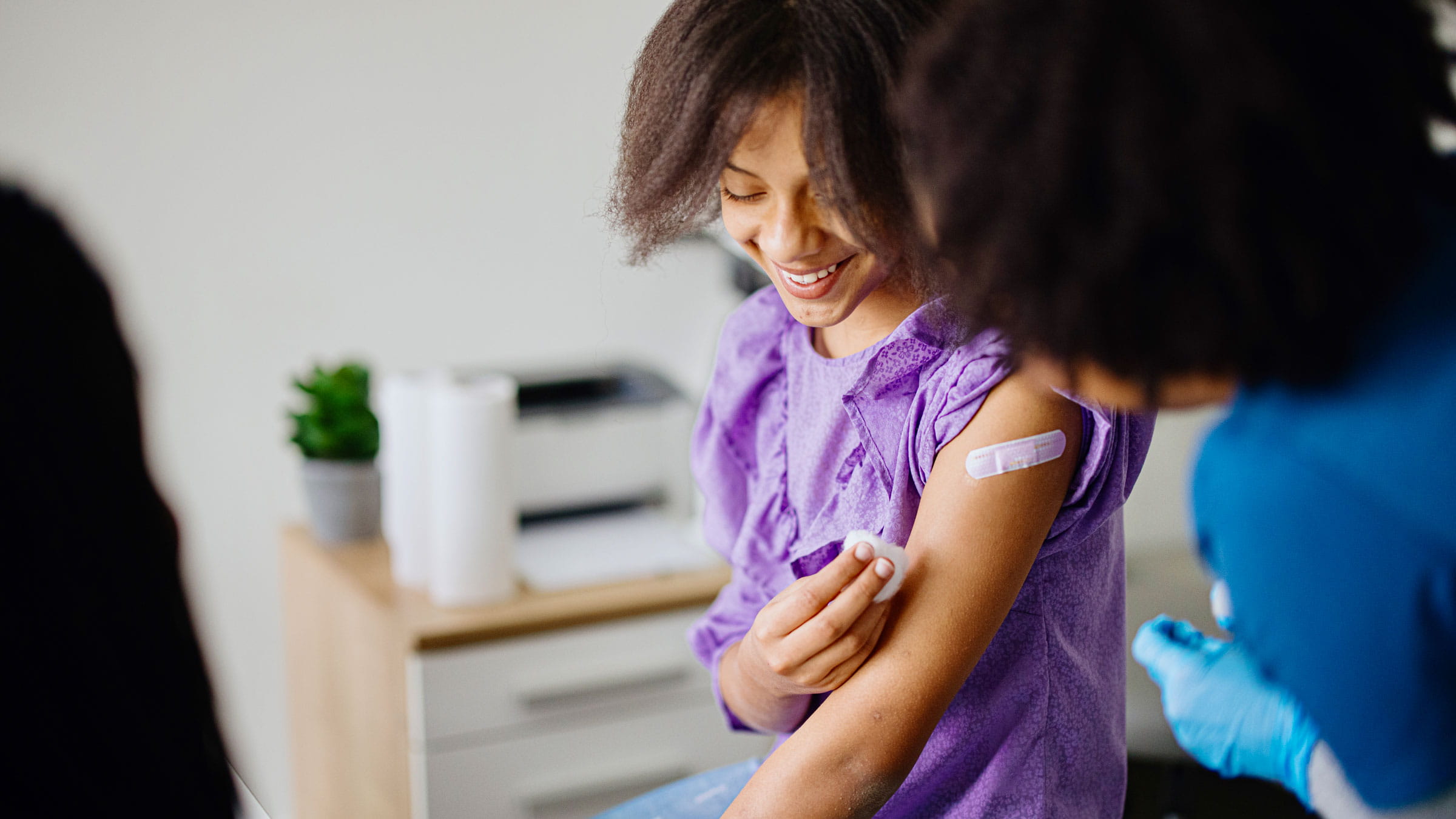 Teen girl with bandage after receiving the HPV vaccination in her arm