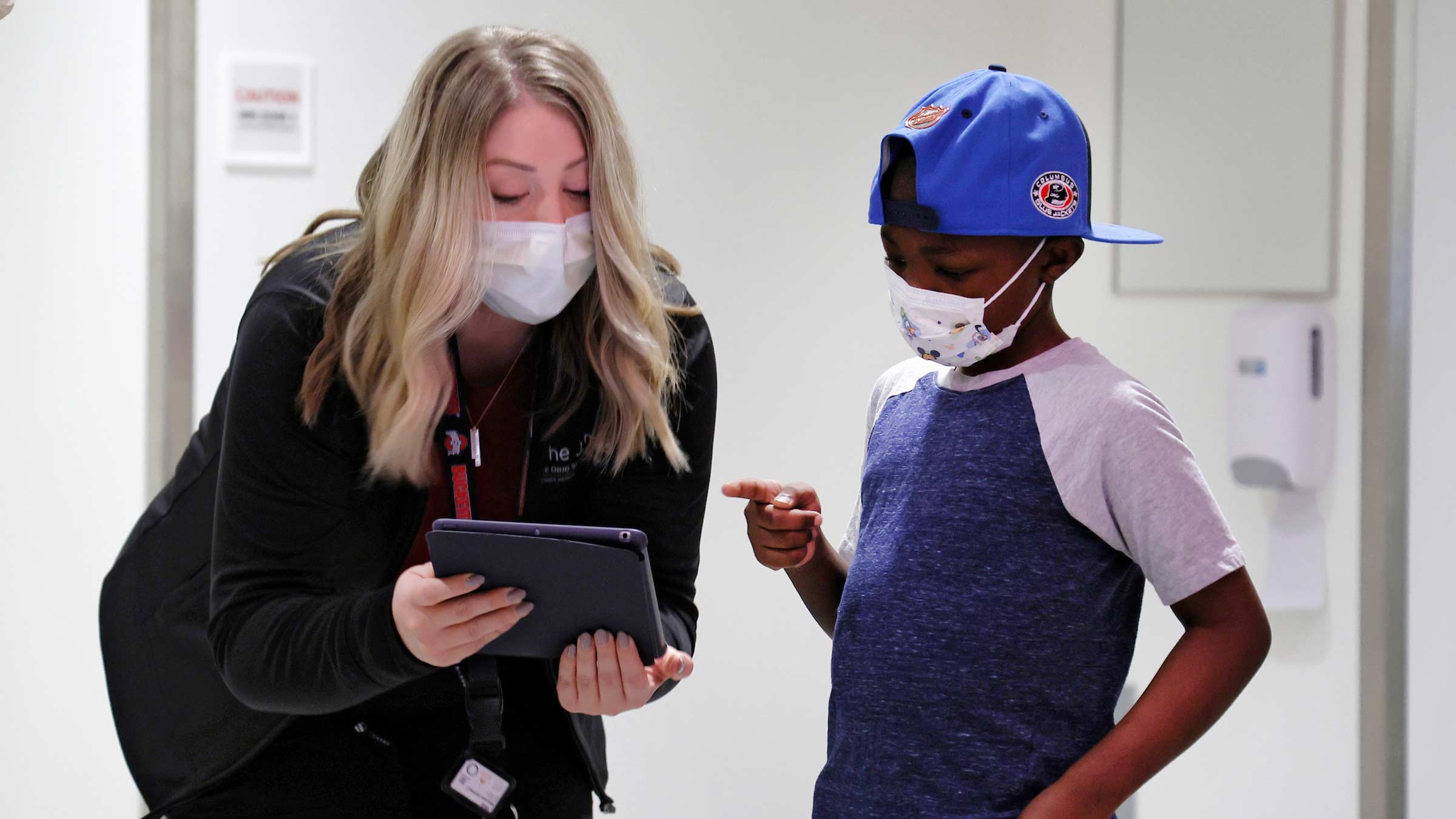 Pediatric cancer patient selecting his mask