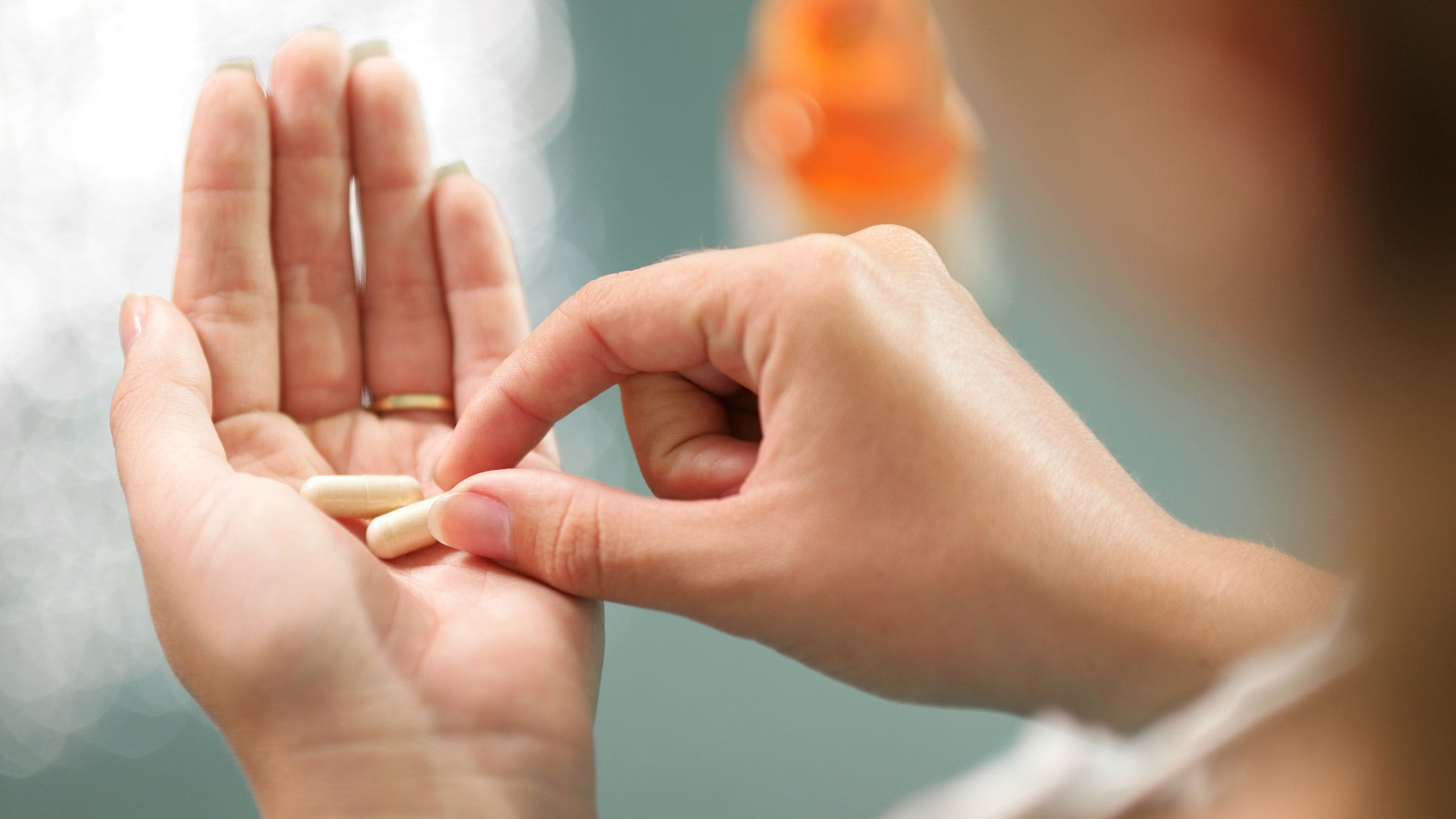 Close-up image of hands holding some supplement pills