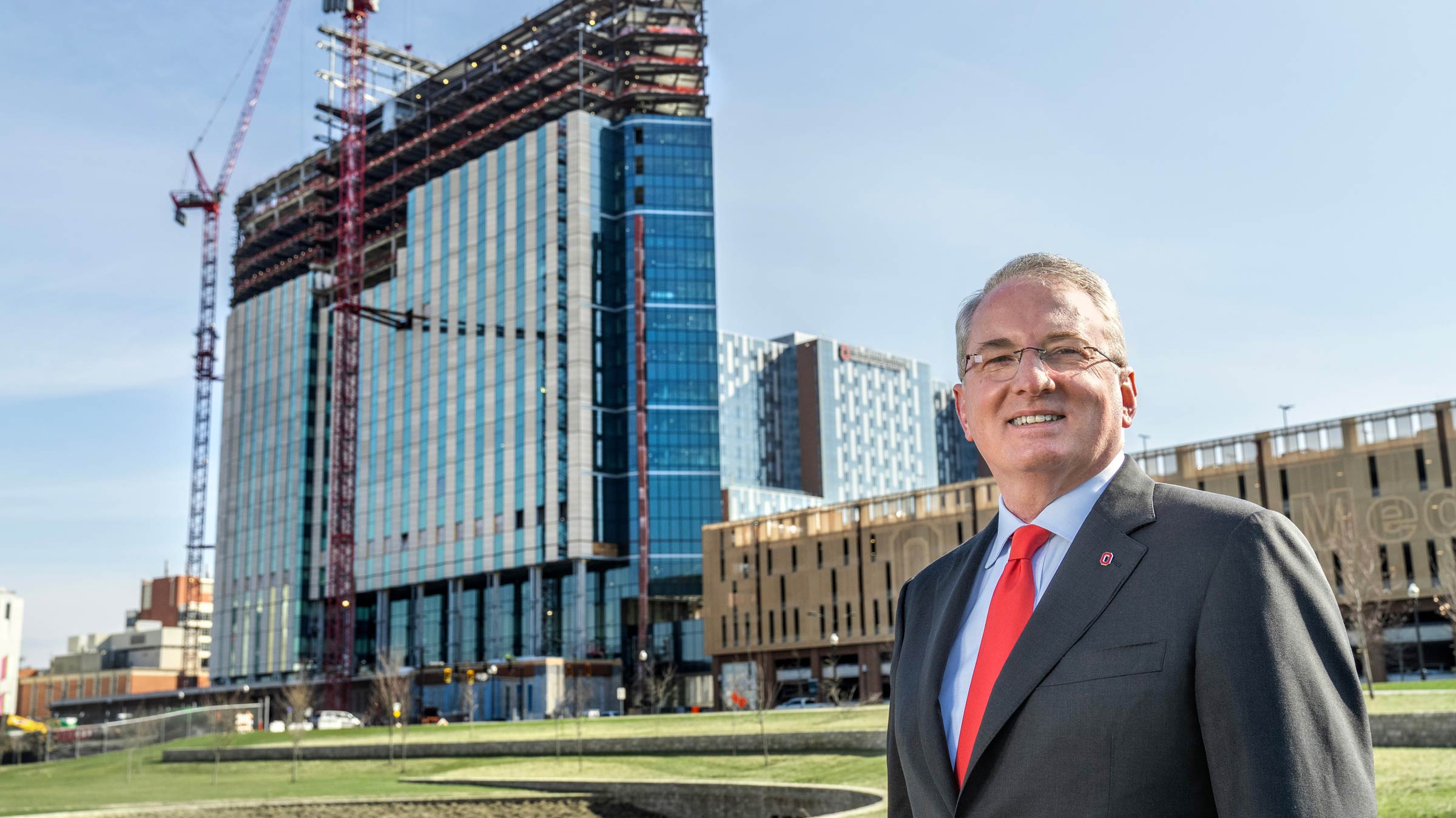 John J. Warner, MD, standing in from of Ohio State's new hospital tower