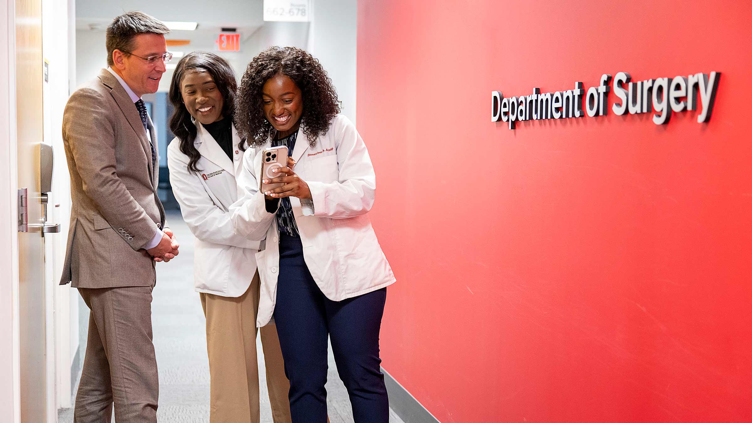 Azap sisters with Dr. Pawlik excitedly checking their phone