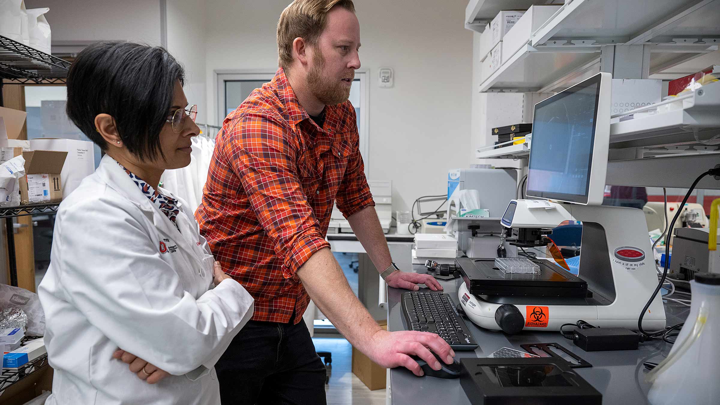 Dr. Skardal with Dr. Dedhia looking at the screen in a lab
