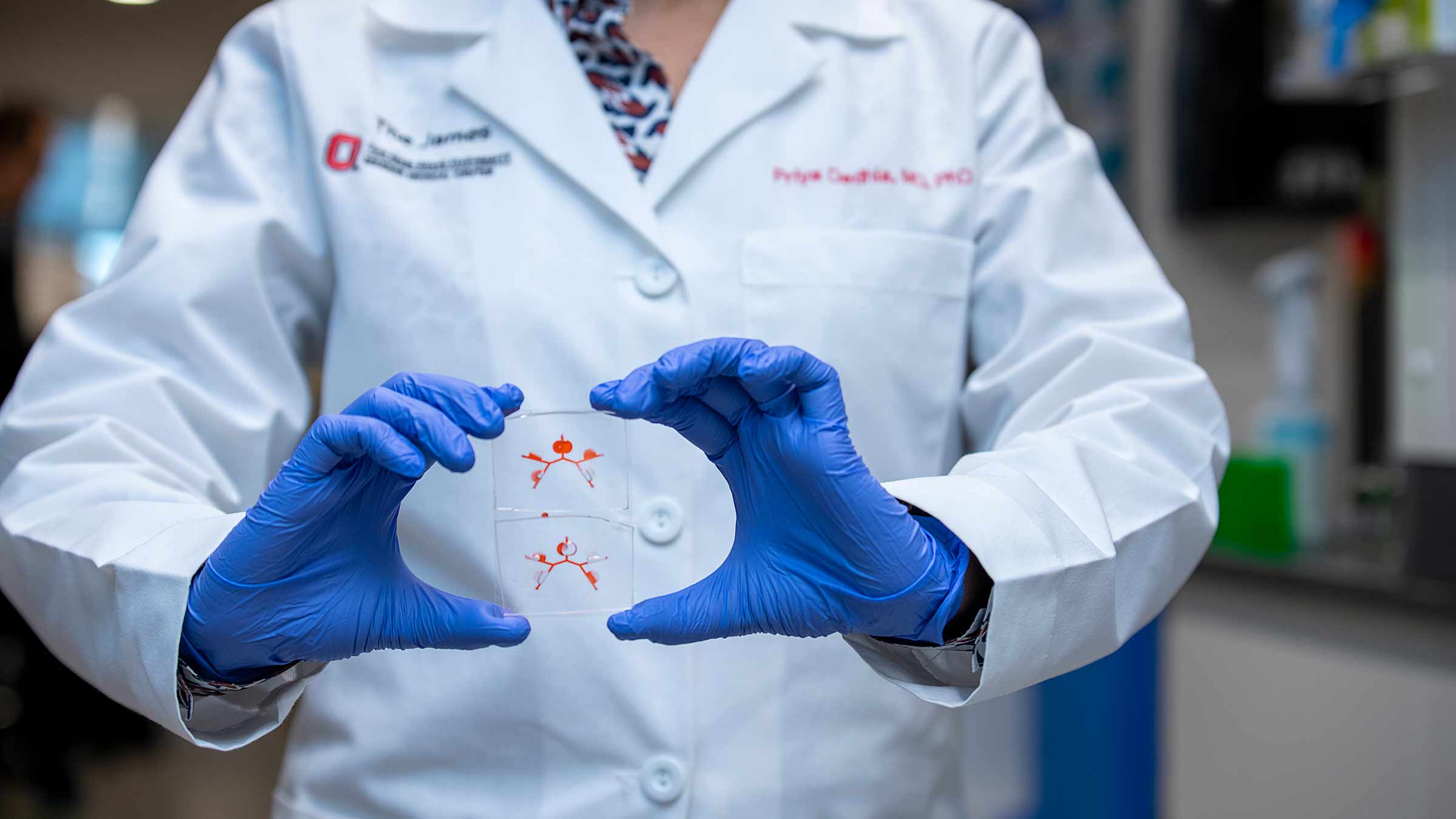 A person in a lab coat holding a sample