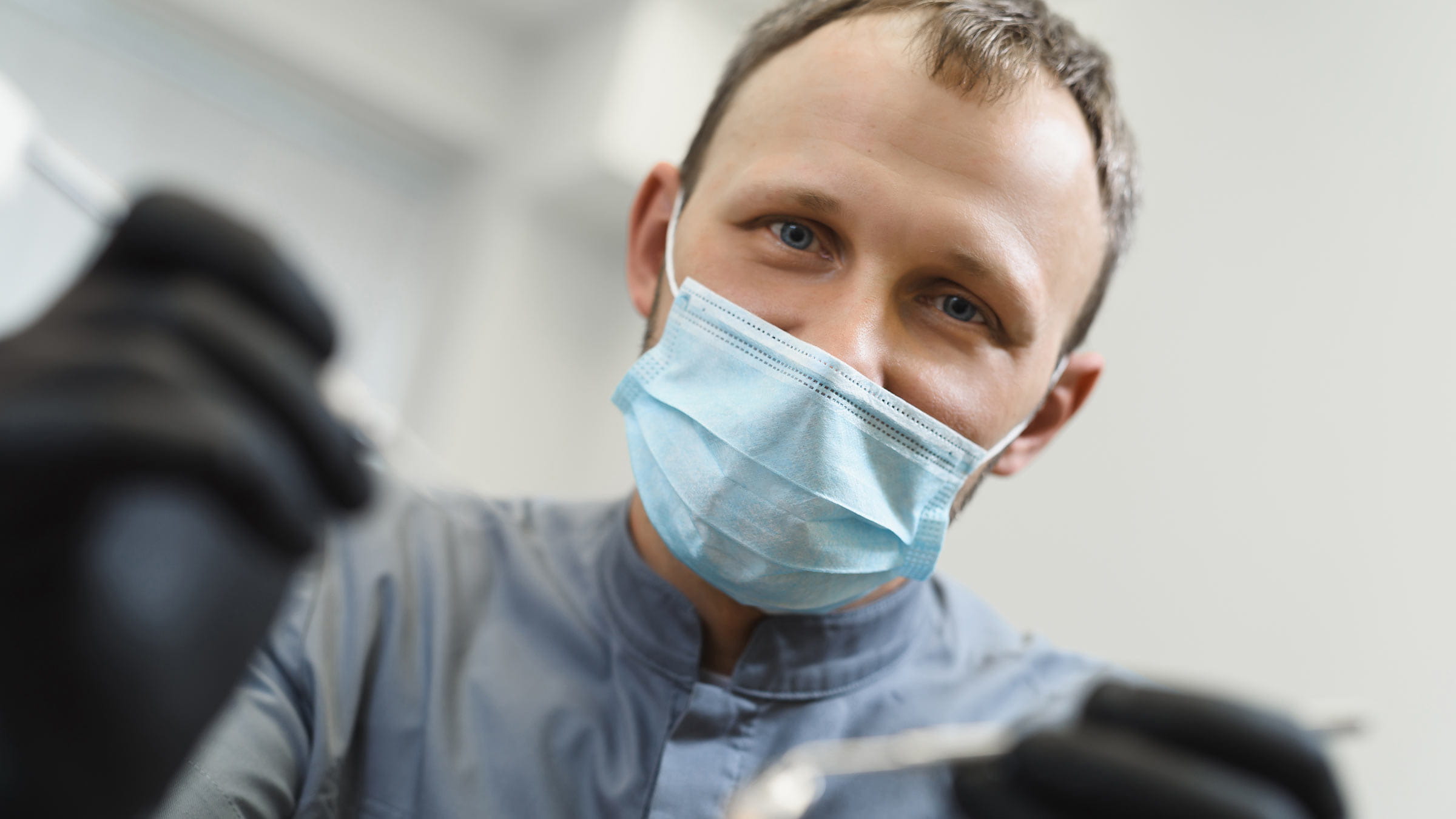 First-person view. Male dentist examines the patient before treatment.