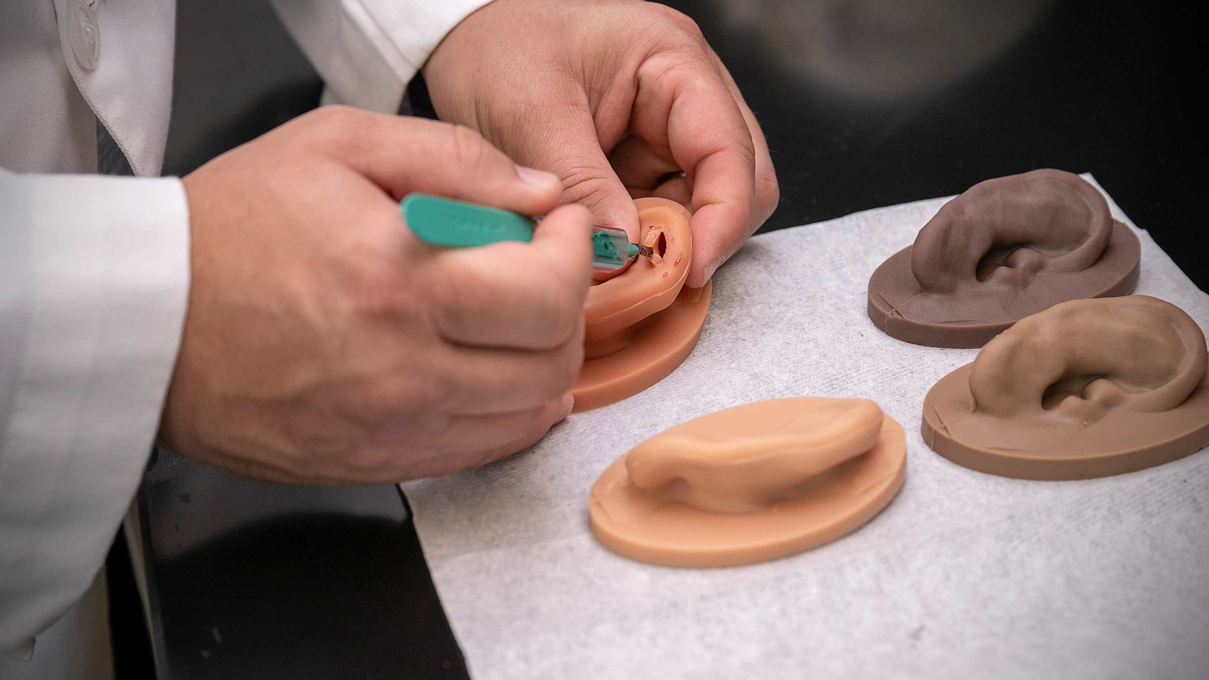 Dr. VanKoevering  making a cut in a 3D model of an ear