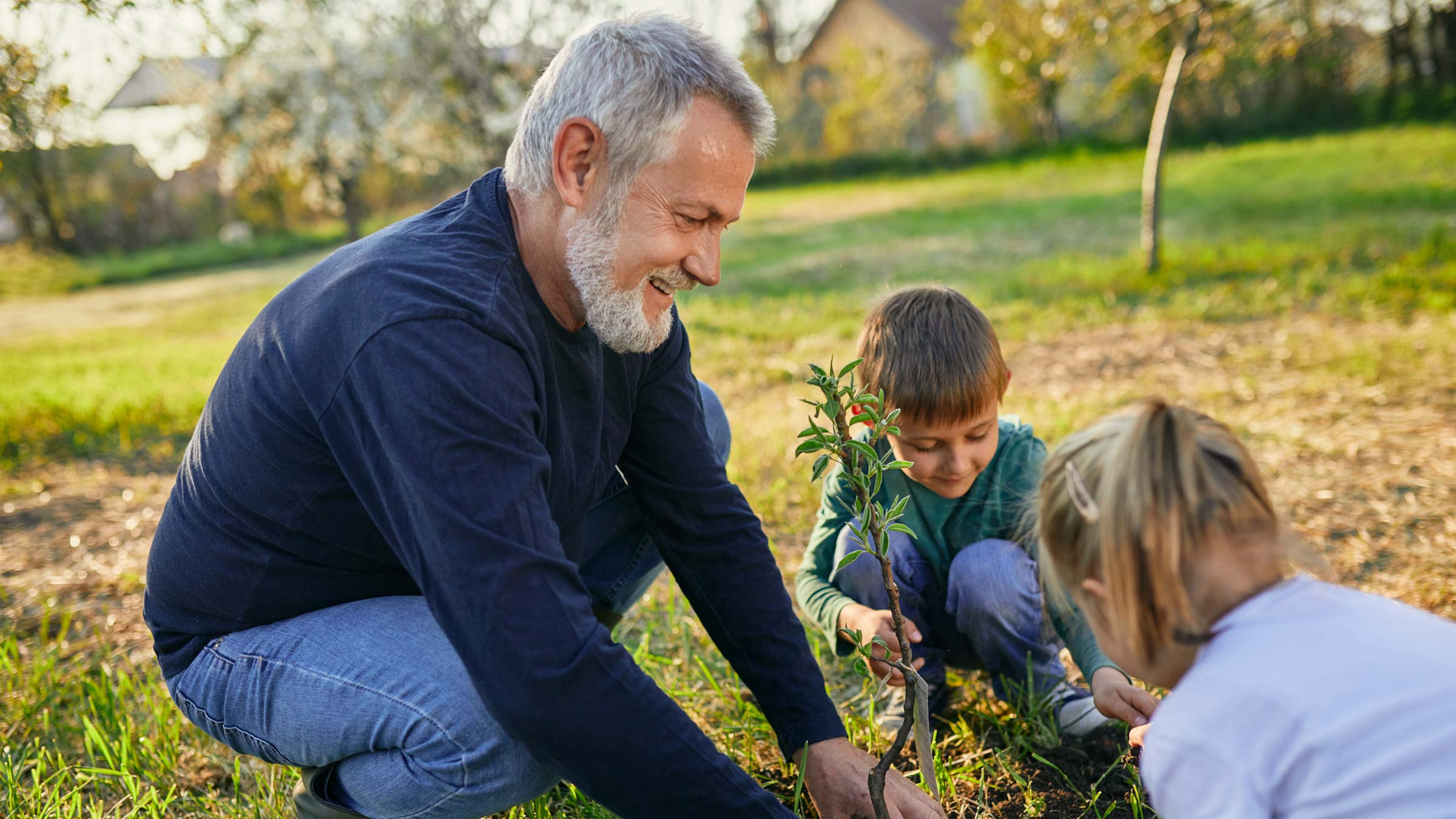 Older man gardening with his grandchildren