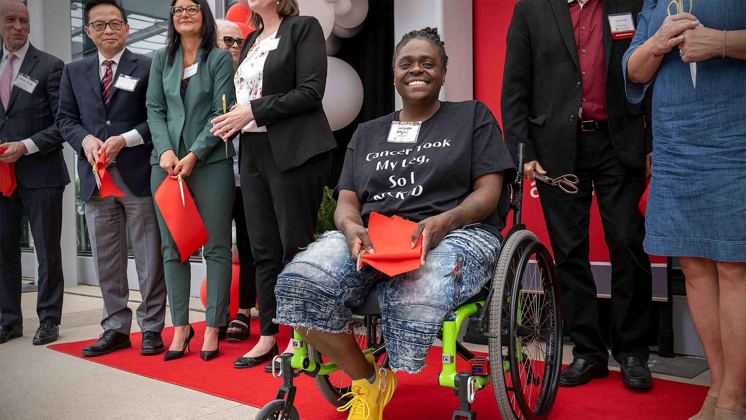 Former cancer patient holding a part of the red ribbon at the opening ceremony