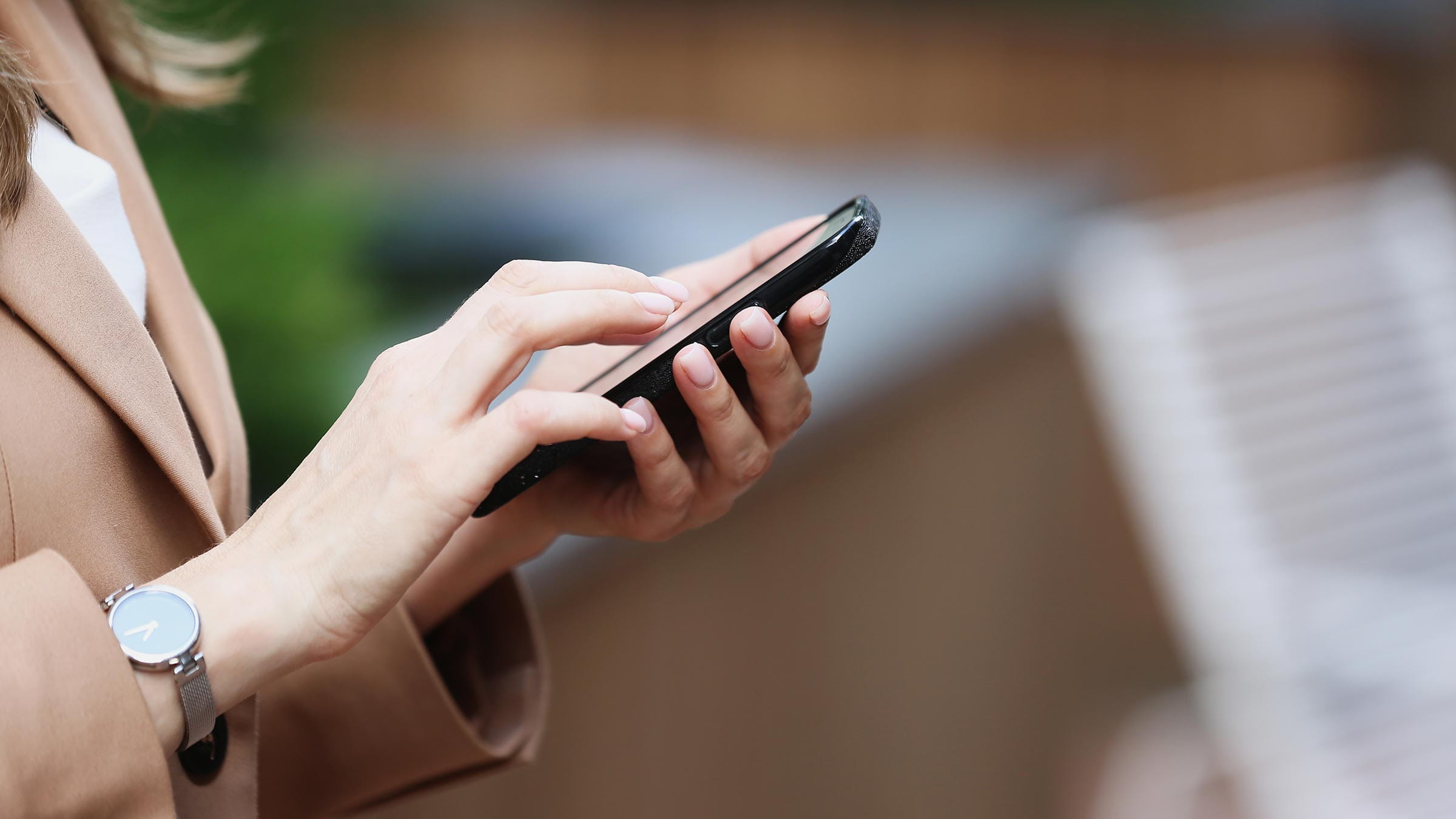 Young adult businesswoman’s hands using smartphone