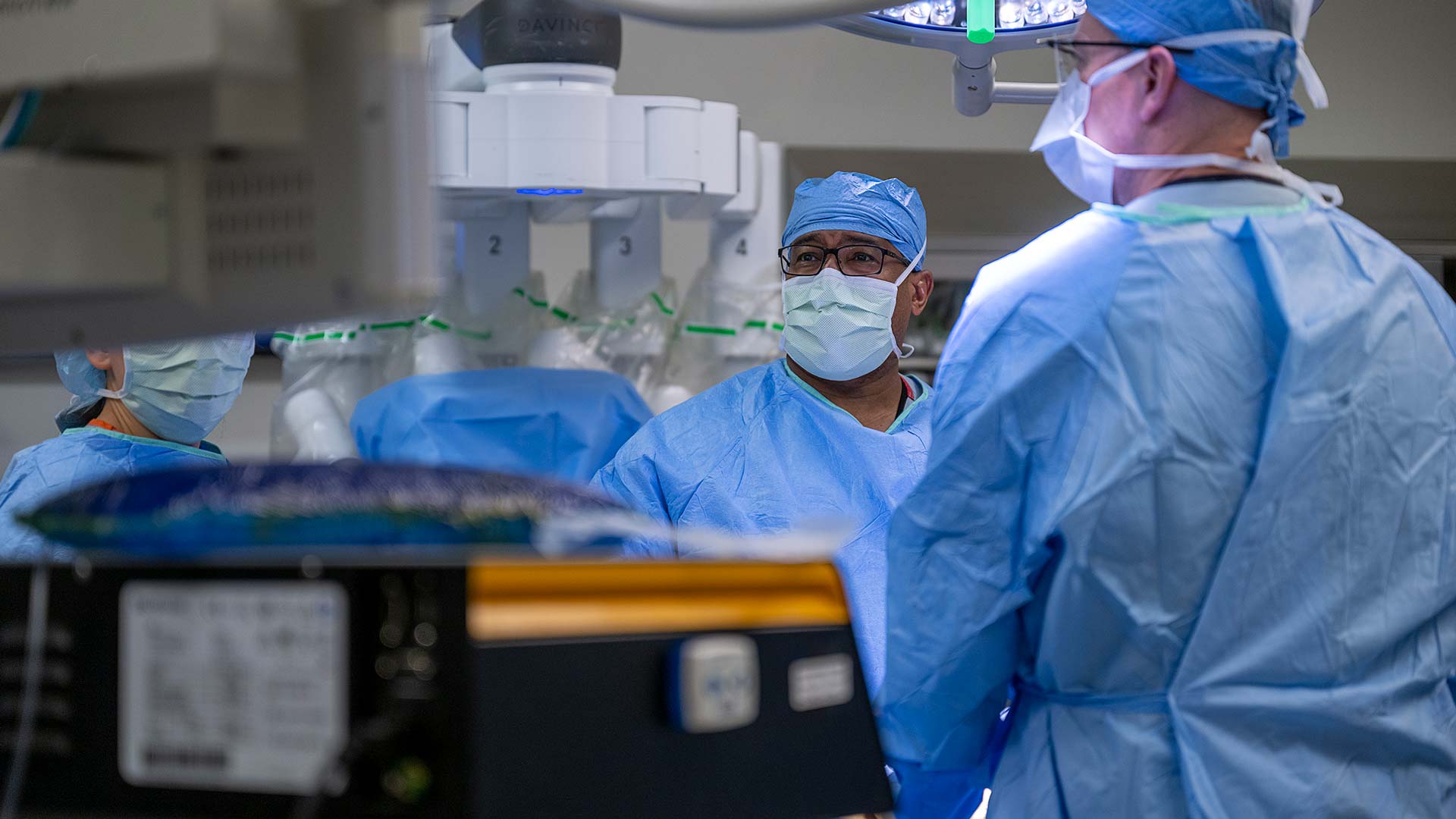 Dr. Merritt in the operating room with the robot on the backgorund