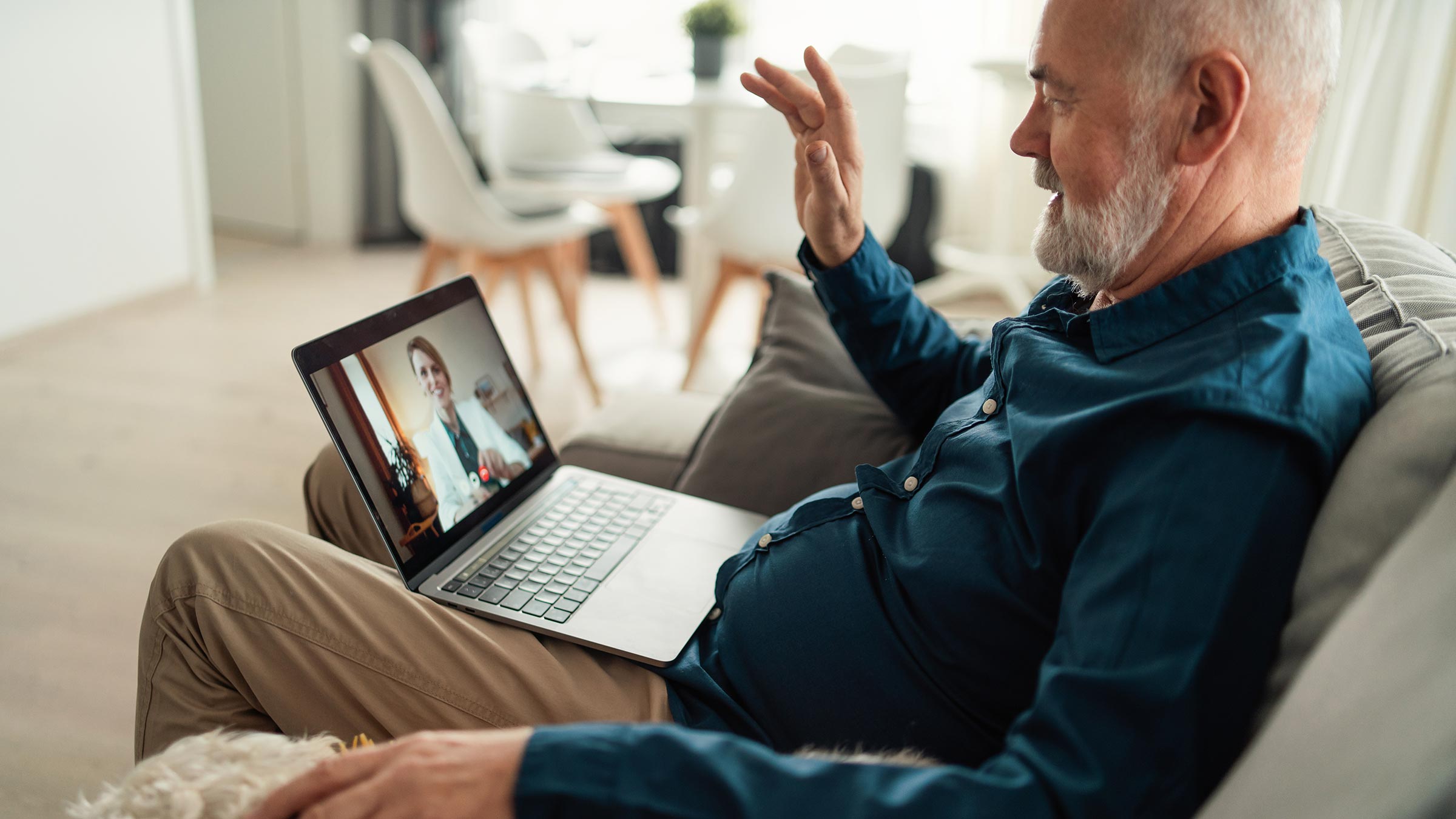 Senior man having a telehealth appointment with his doctor via a laptop