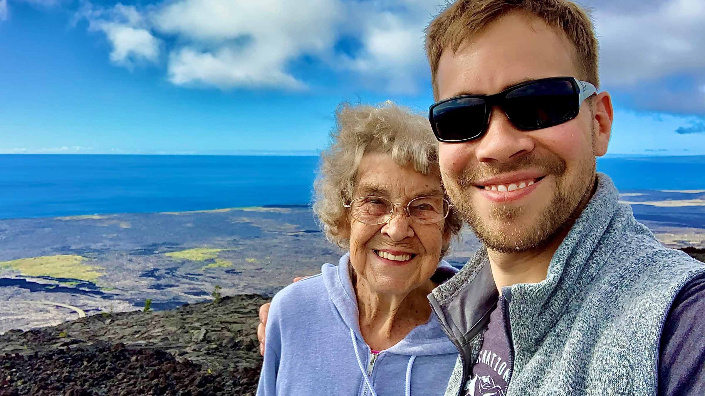 Brad Ryan and his grandmother on top of the mountain with a view of the ocean