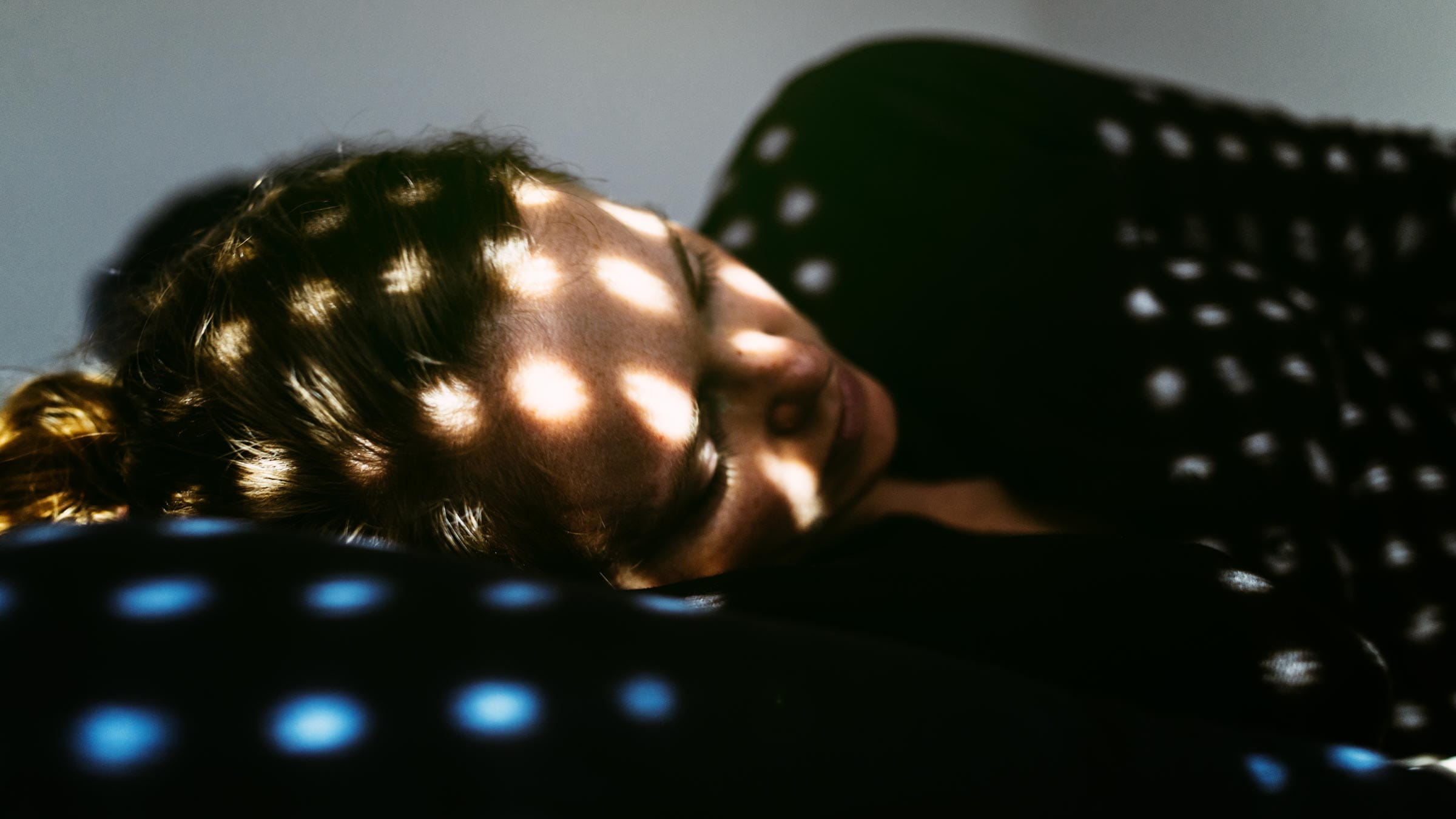 Depressed woman lying in a dark room