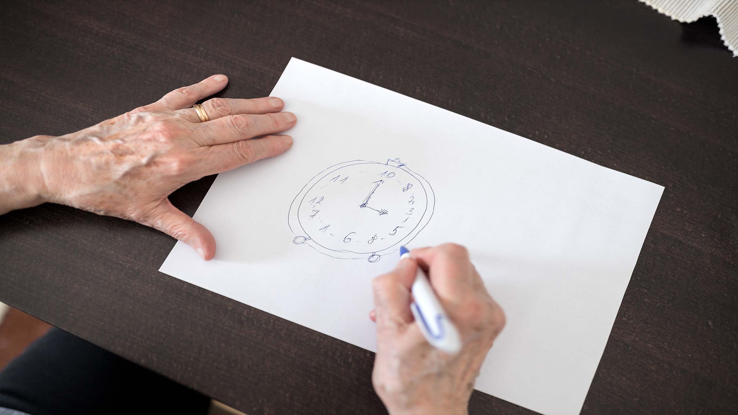 Close up of an elderly patients' hands working on an Alzheimer's disease test