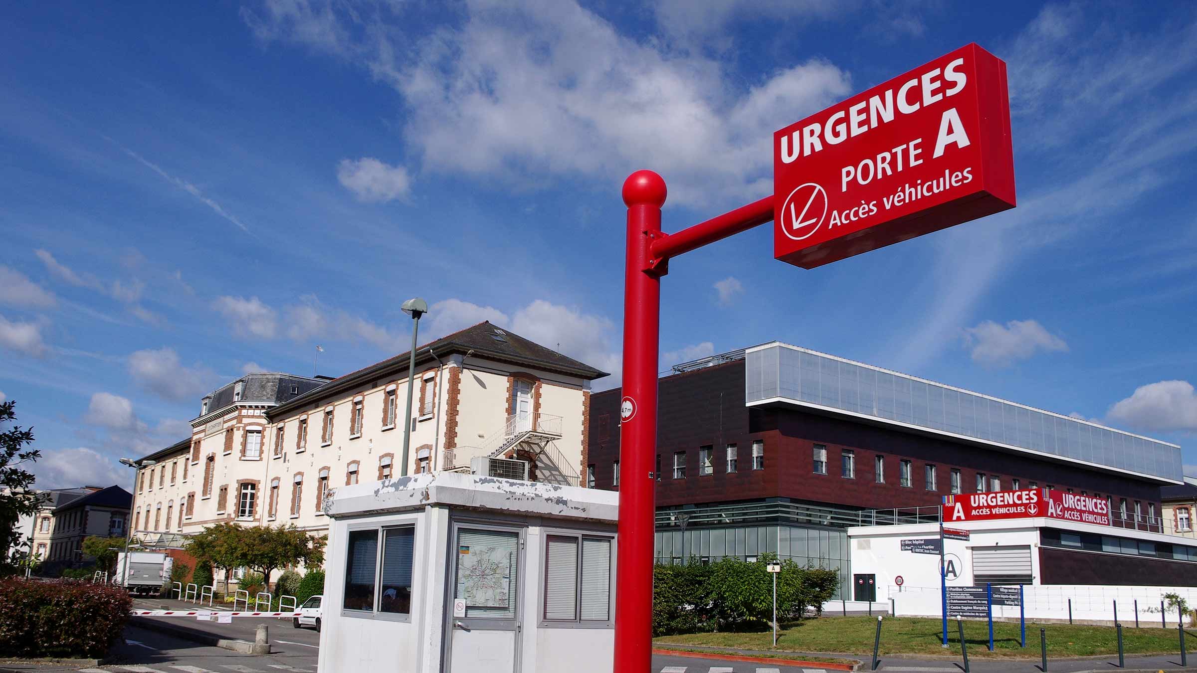 Red urgent care sign, in French, pointing to car access