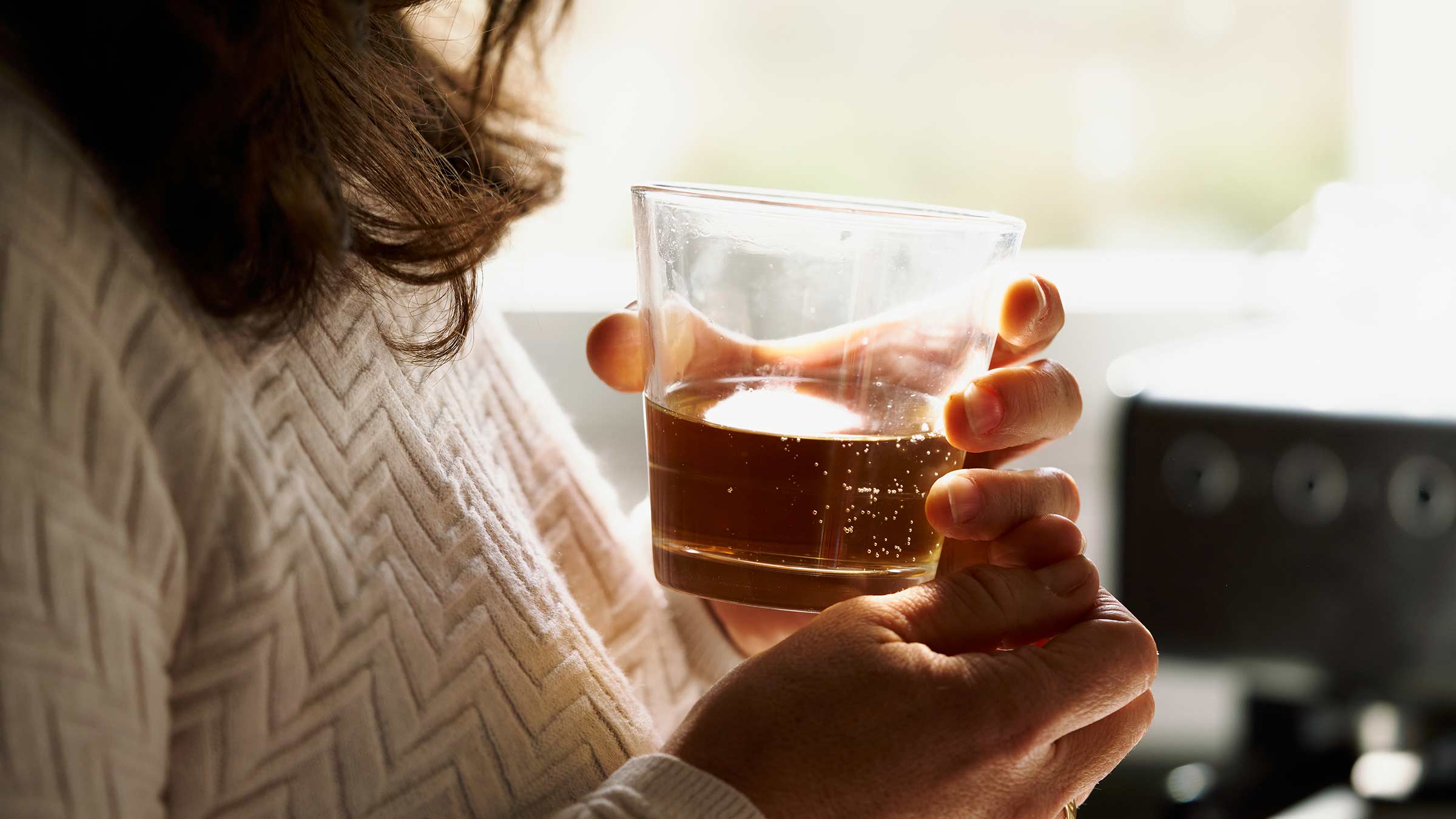 Woman holding a glass of alcohol in her hands