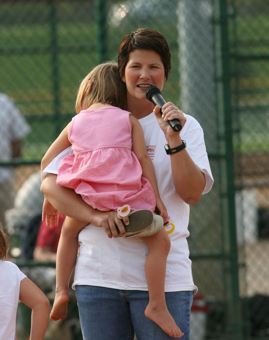 Stefanie Spielman speaking while holding her sleeping daughter