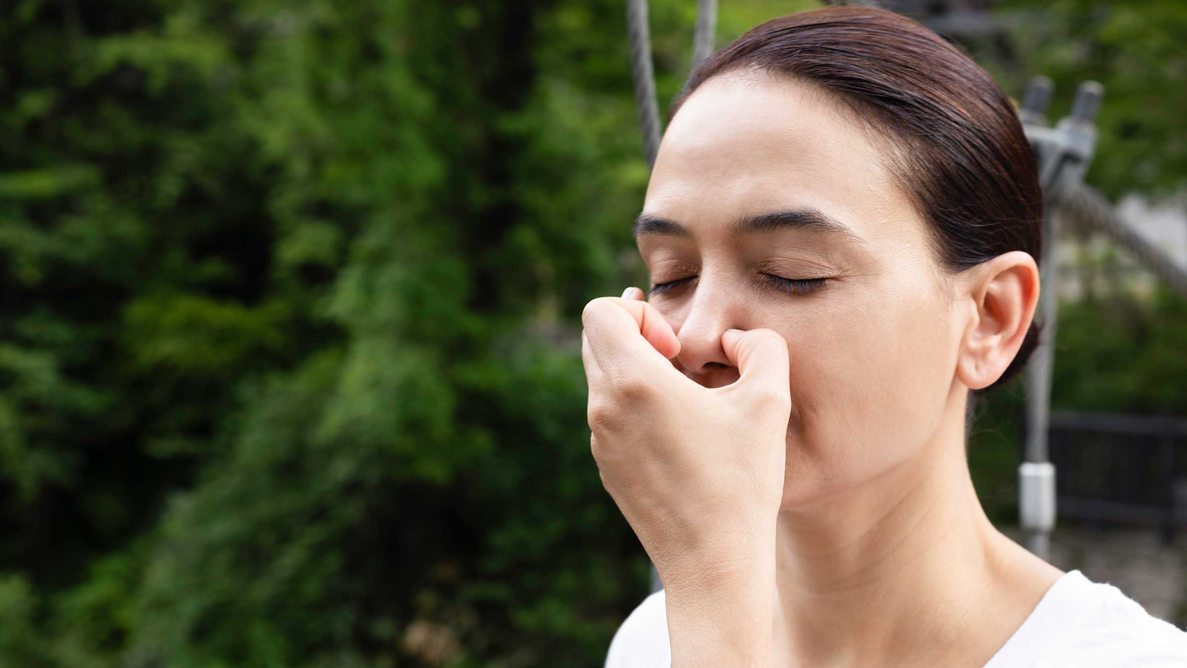 Woman doing breathing exercise with her eyes closed