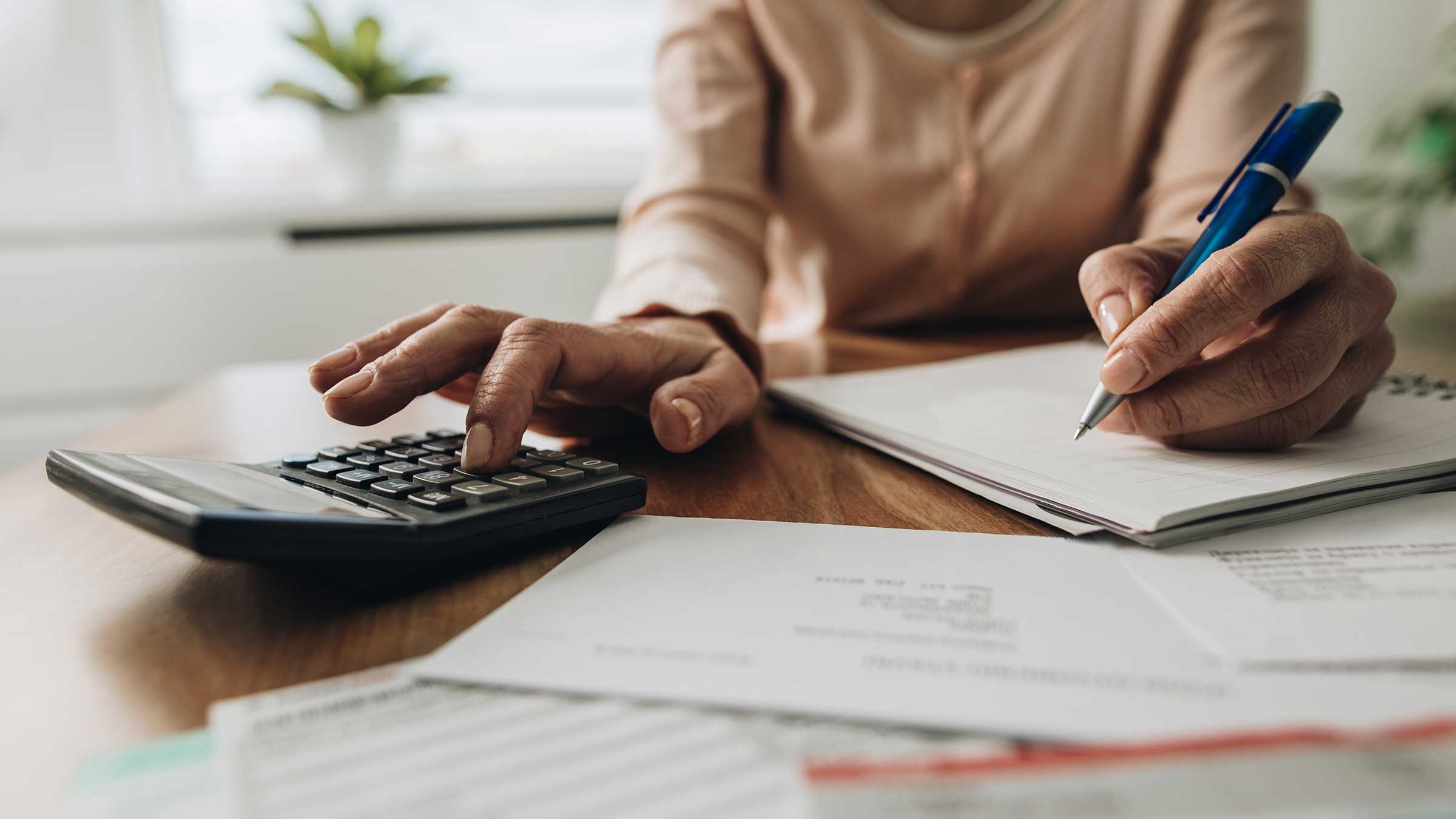 A woman with a calculator going through bills