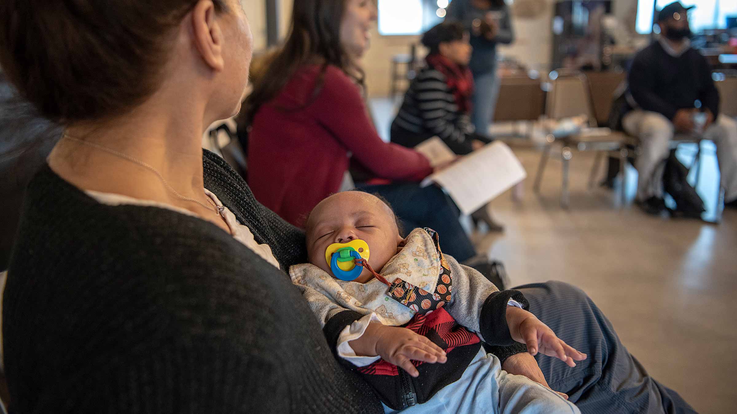 A baby soundly asleep in a woman's arms