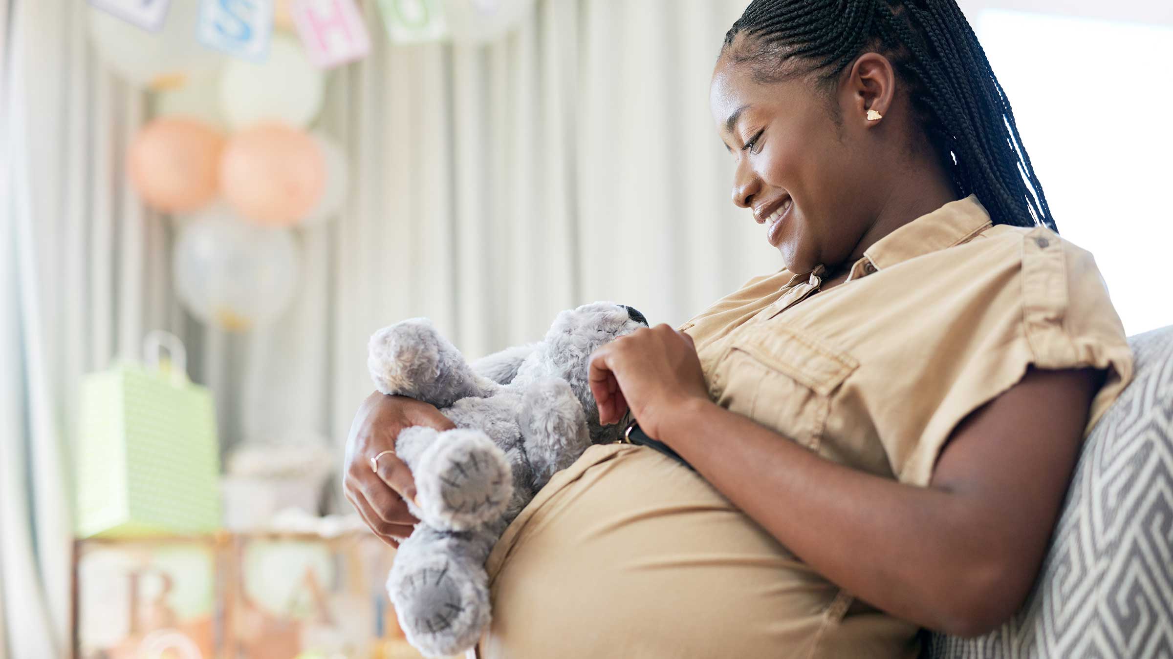 Pregnant woman sitting in a chair holding a stuffed animal
