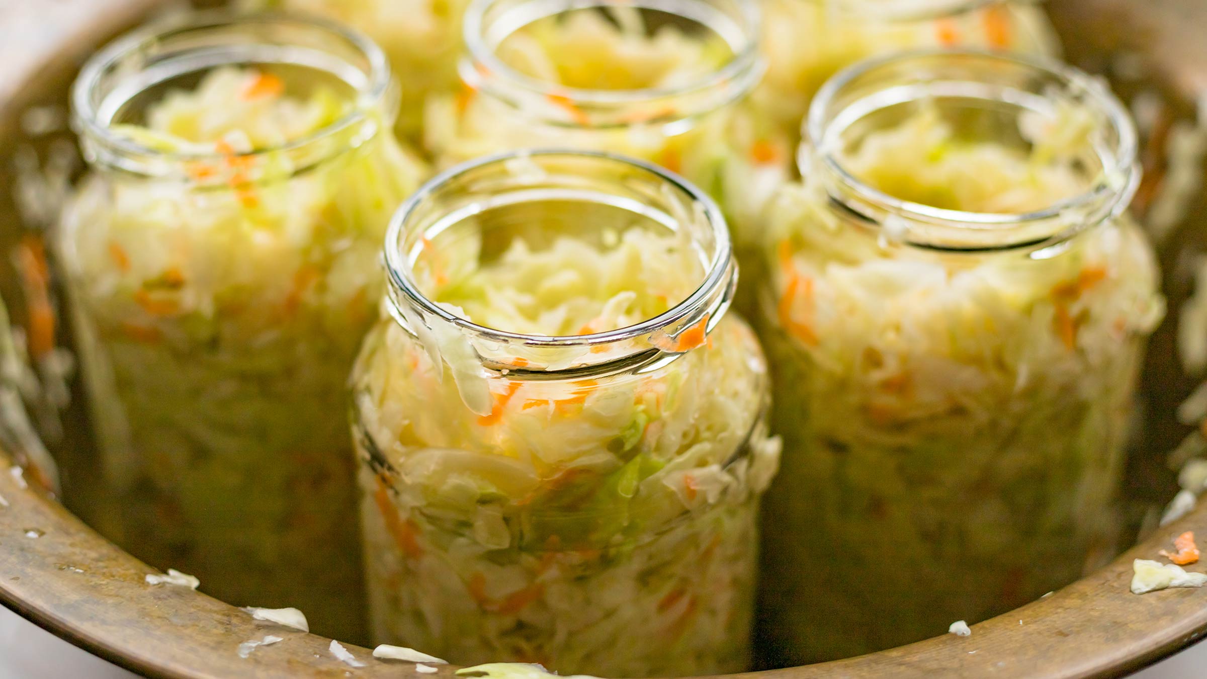 Cut white cabbage in glass jars fermenting into sauerkraut