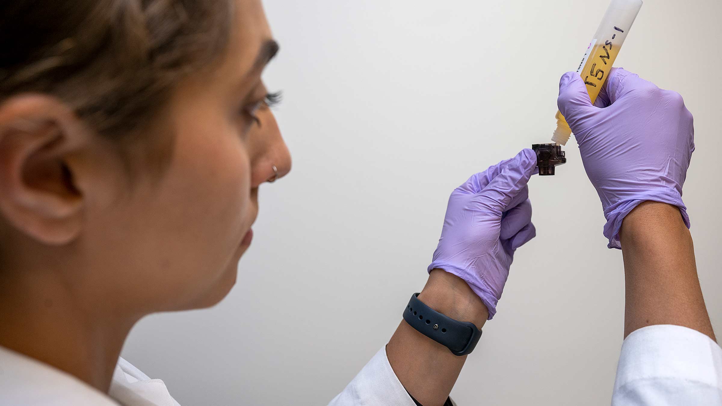 Researcher fills an e-cigarette pod with e-liquid