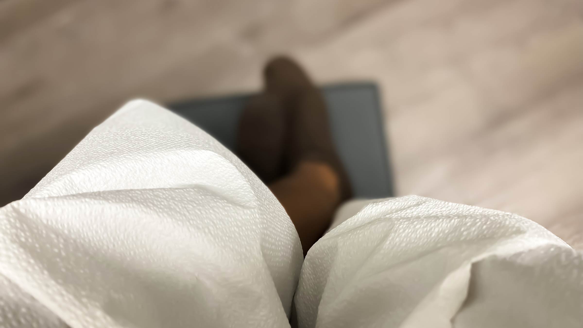 Image from the perspective of a patient wearing a medical gown staring at the floor