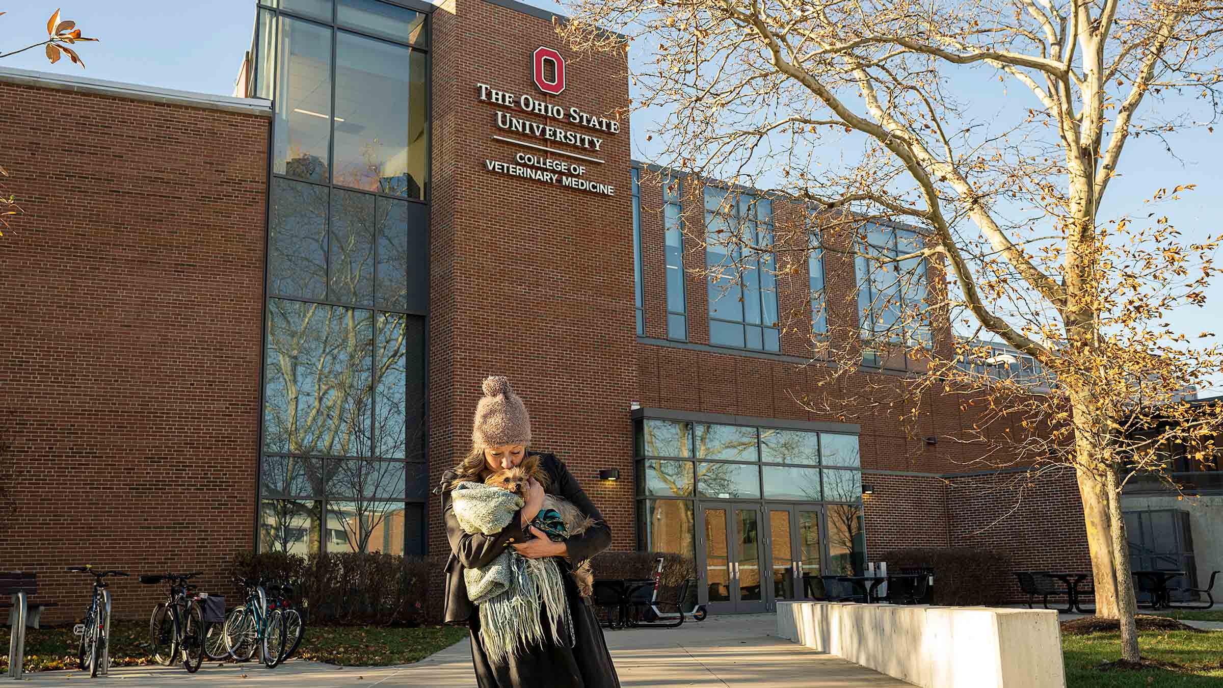 Dr. Acton holding Winnie in her arms in front of the Ohio State College of Veterinary Medicine building