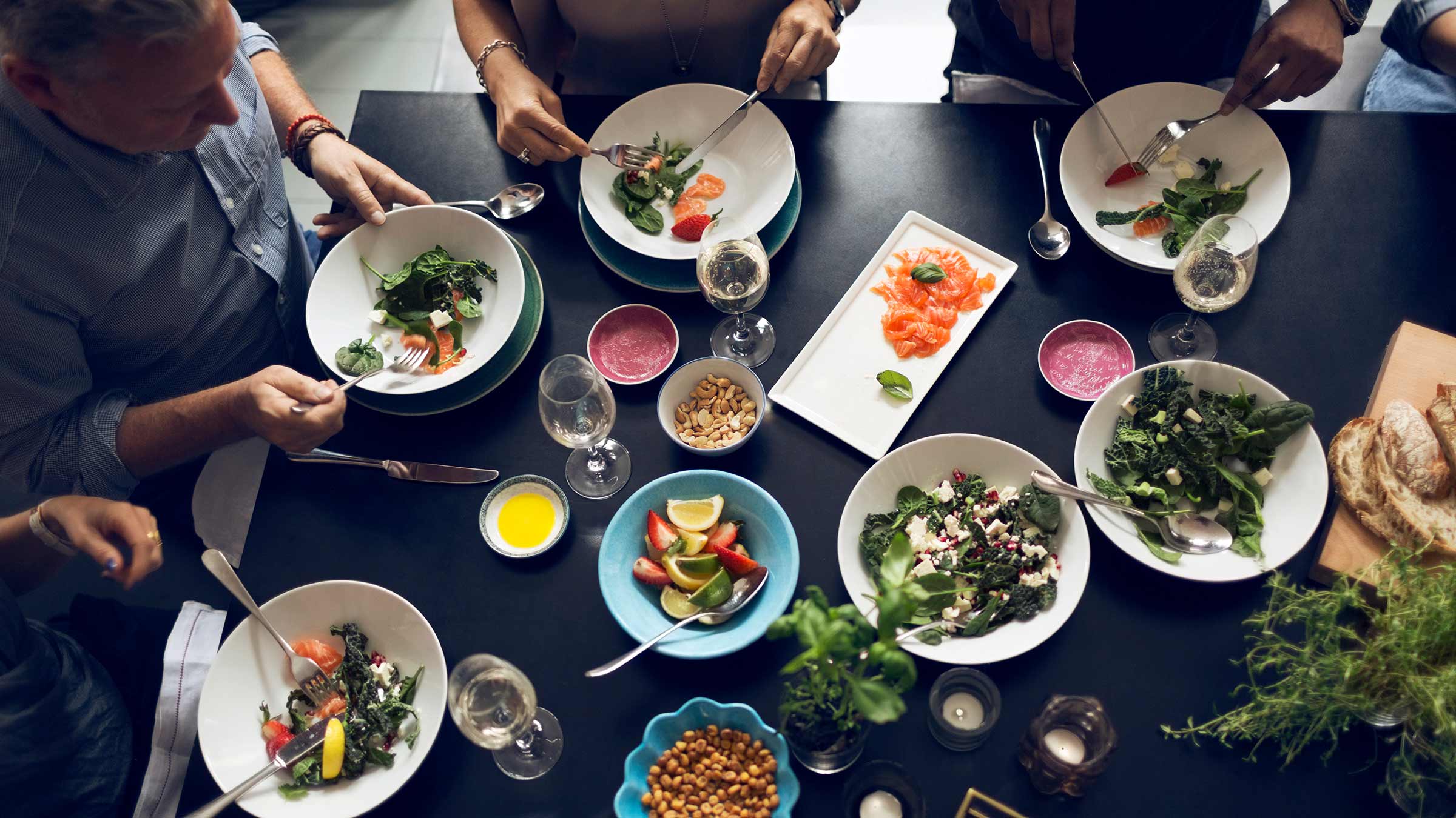 High angle view of friends gathered around a table sharing food