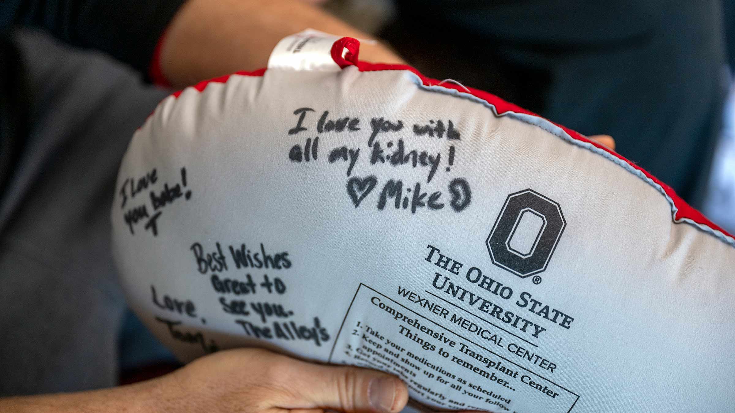 A kidney pillow with handwritten messages, one of them reads: "I love you with all my kidney. Mike."