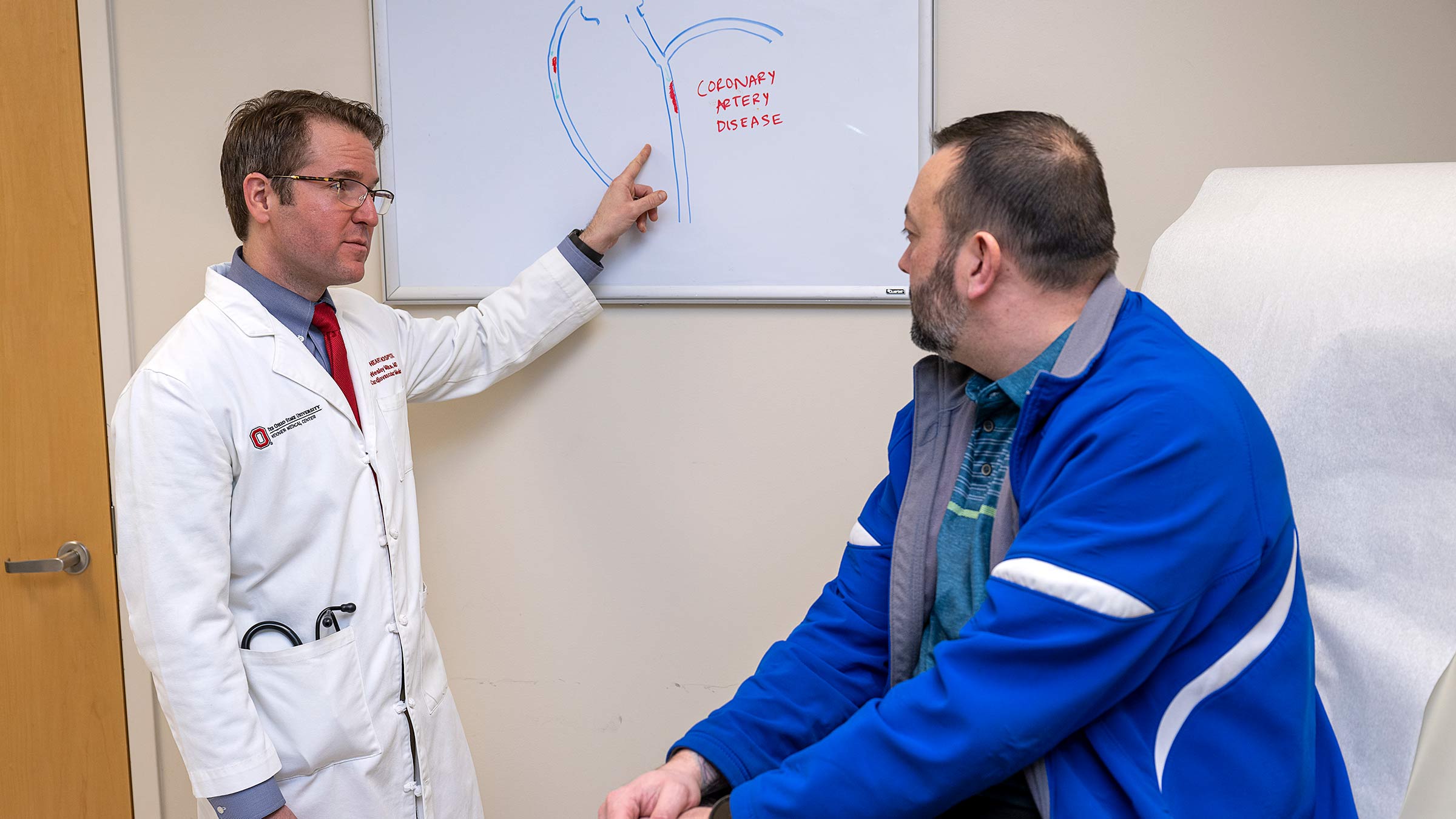 Dr. Milks talking to a patient pointing to a whiteboard