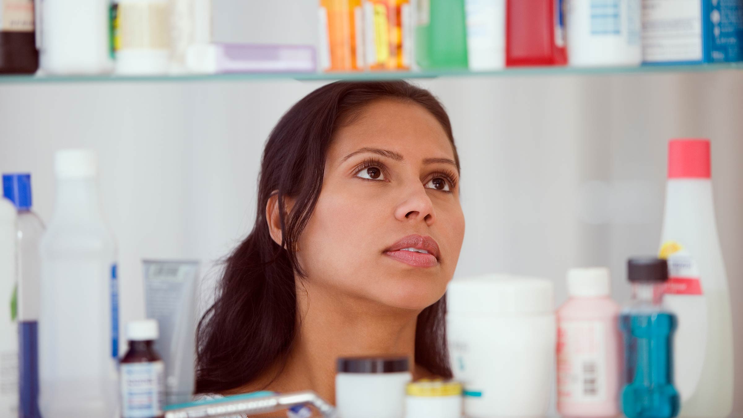 Woman looking at the contents of her medicine cabinet