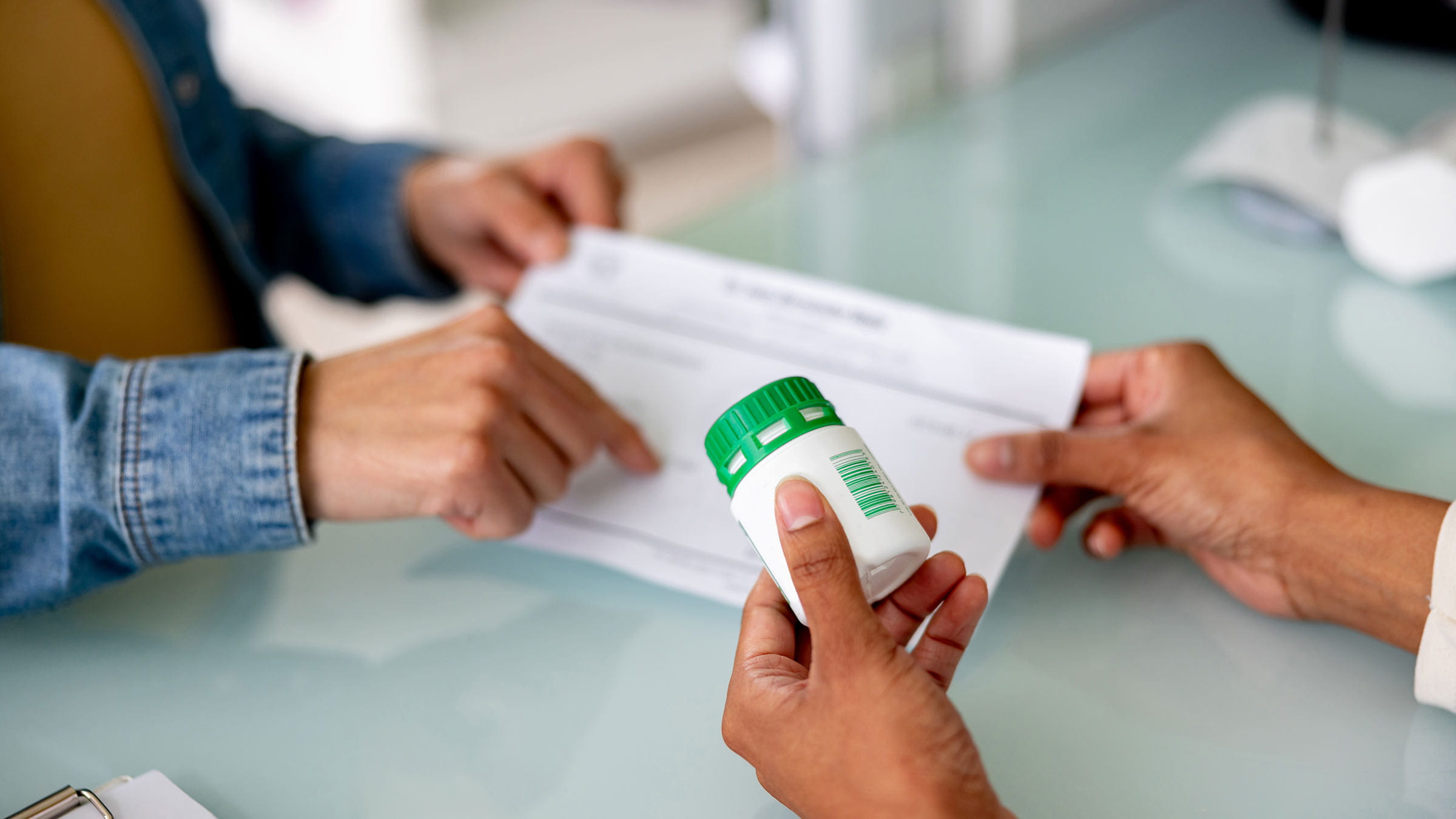 A pharmacist handing medication to a customer