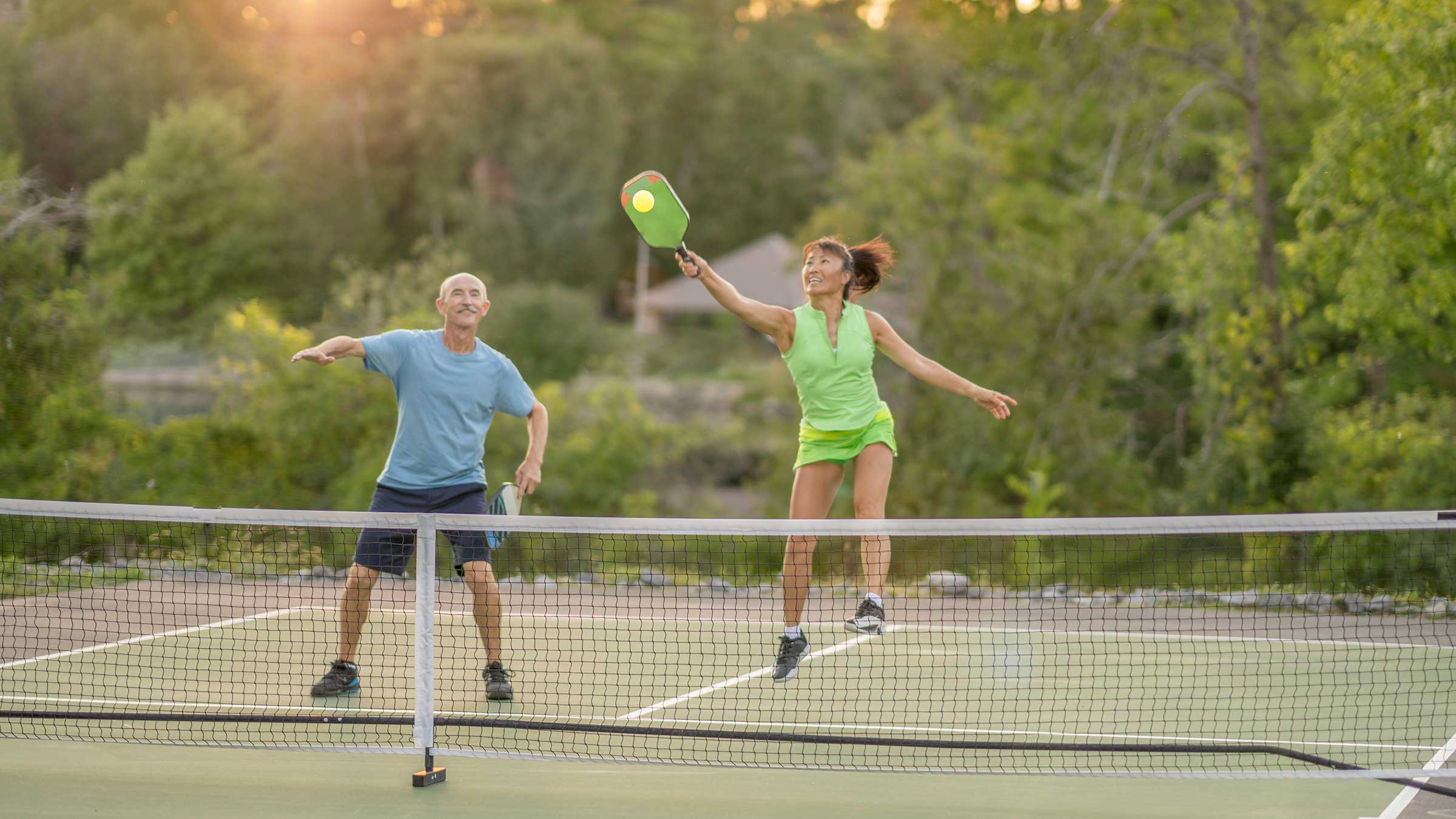 A man and a woman playing pickleball