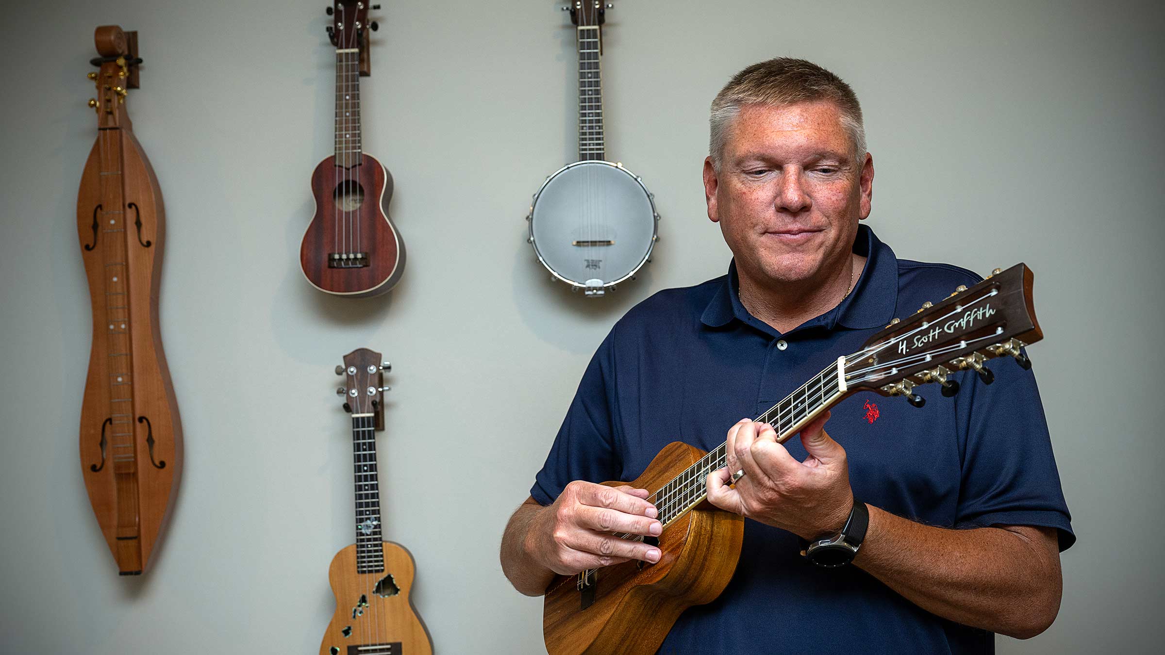 Scott Griffith standing in front of his ukulele collection