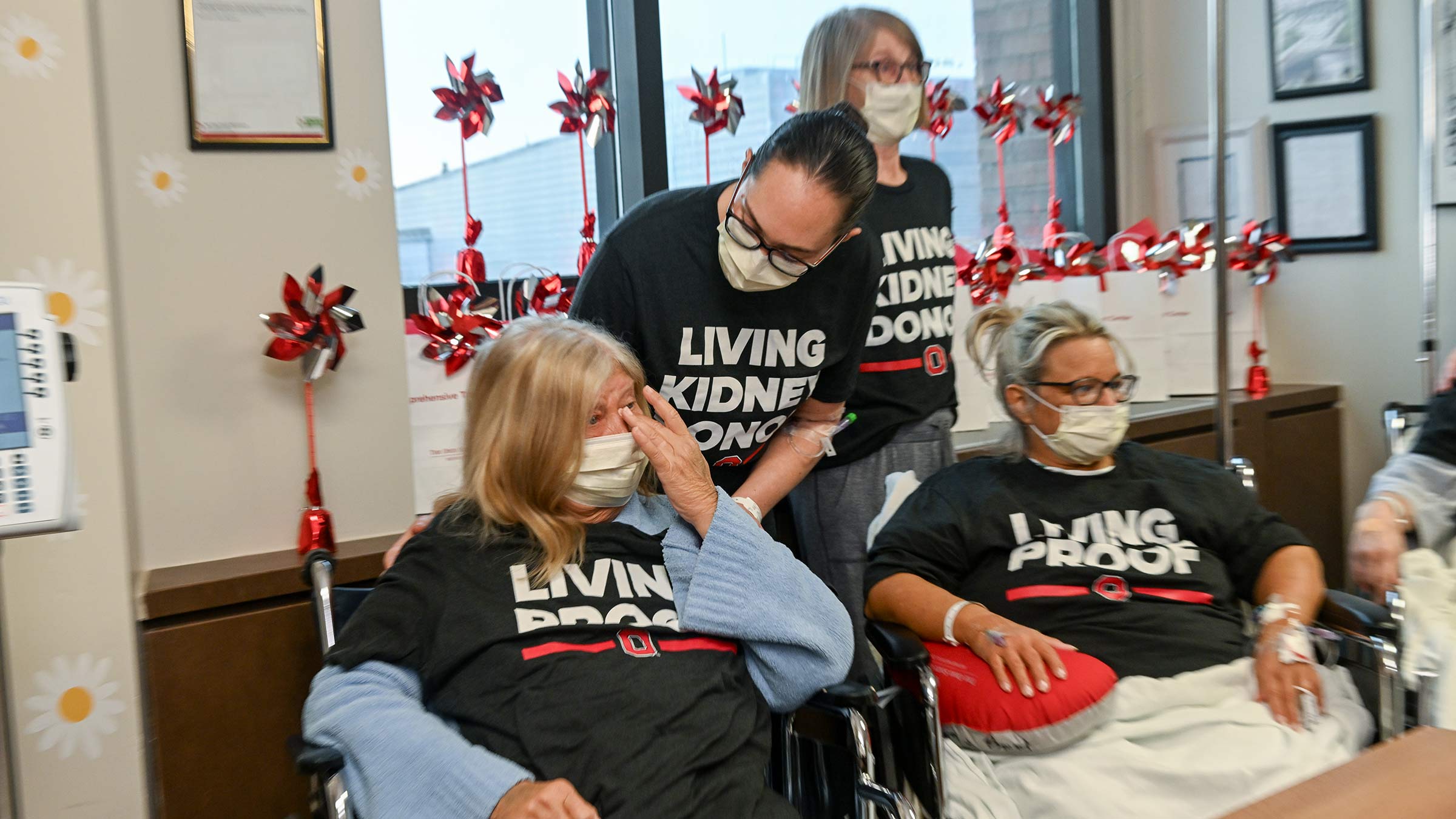 Two women sitting down wearing "Living proof" T-shirts, and two other women standing up behind them wearing "Living kidney donor" T-shirts