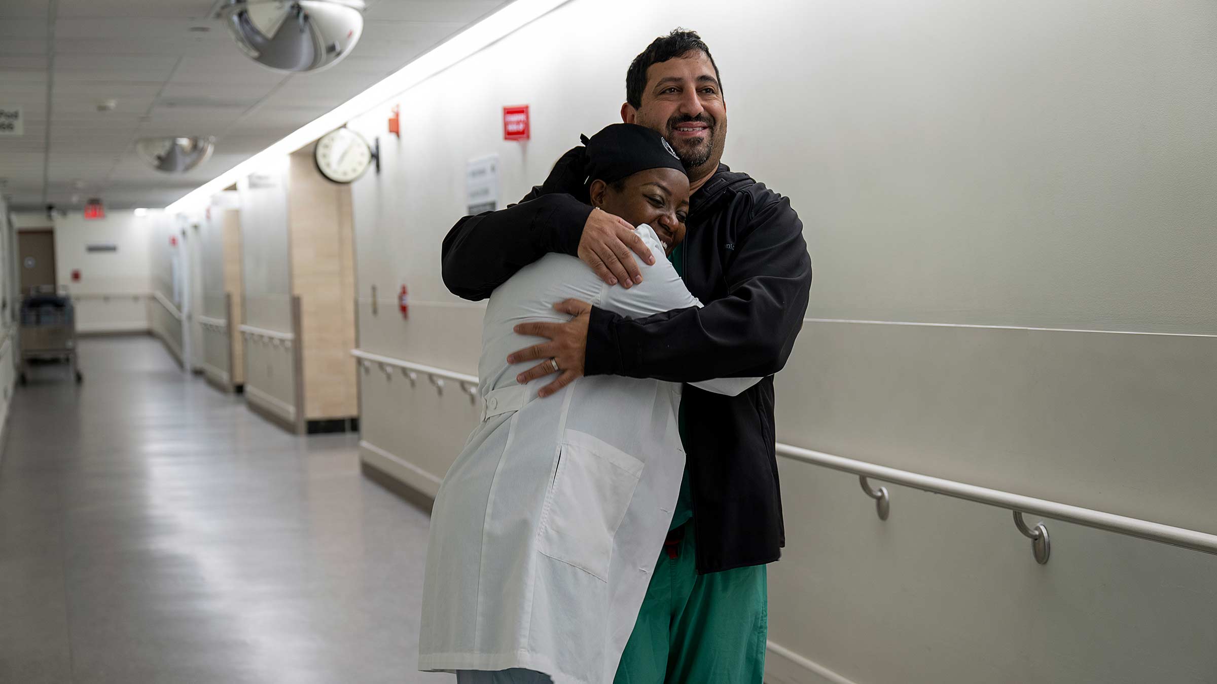 Dr. Kerrry-Ann Mitchell and Dr. Patrick Youseef hug in the hallway of the hospital